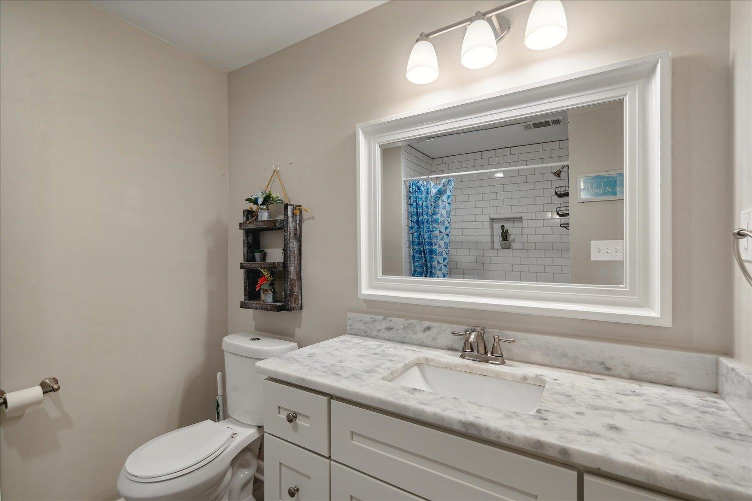 Bathroom with walk in shower, vanity, and toilet