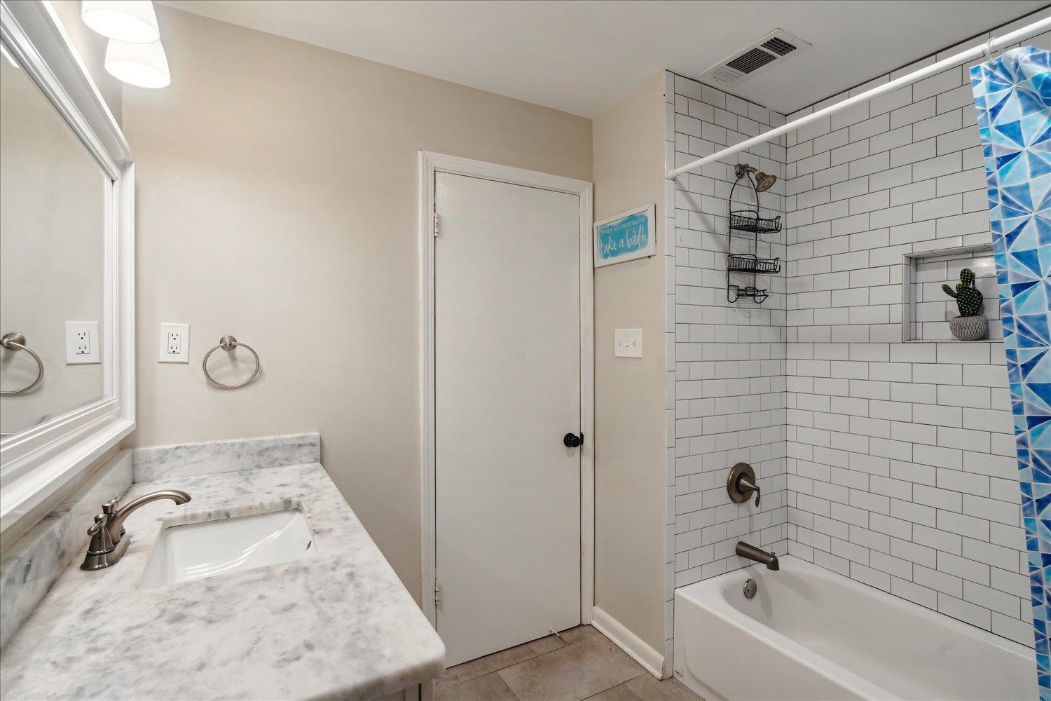 Bathroom featuring tile patterned flooring, shower / bath combo, and vanity