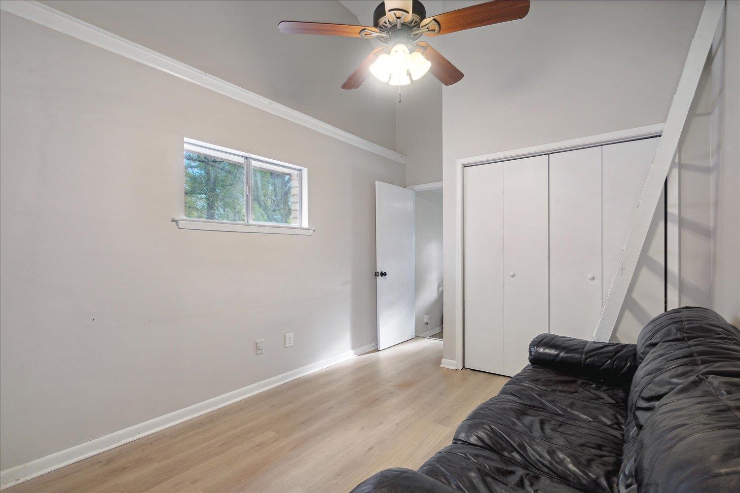 Living room with crown molding, ceiling fan, and light hardwood / wood-style floors