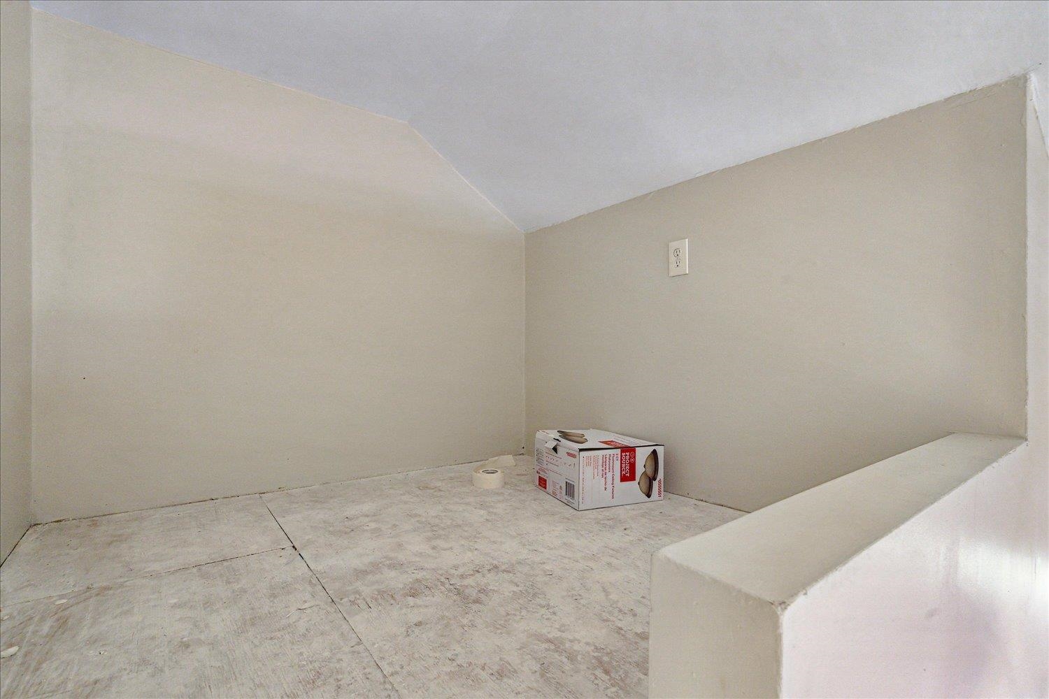 Empty room with lofted ceiling