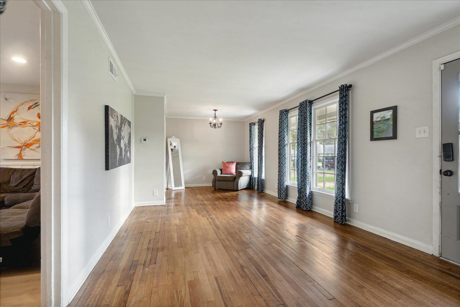 Interior space with crown molding, an inviting chandelier, and hardwood / wood-style flooring