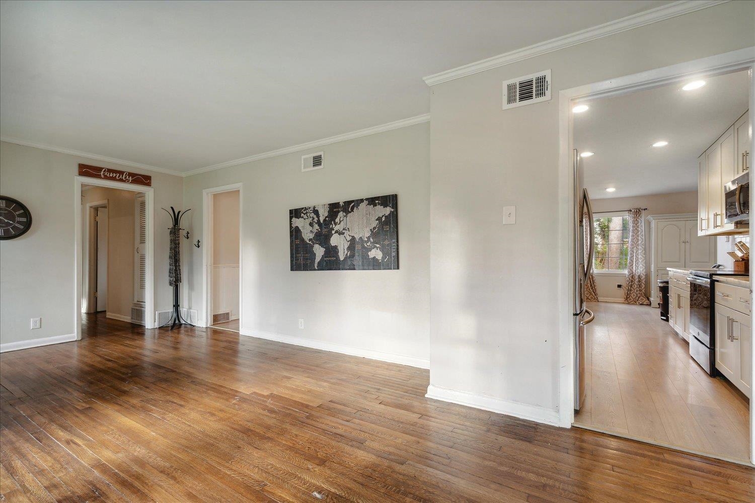Empty room with hardwood / wood-style floors and ornamental molding