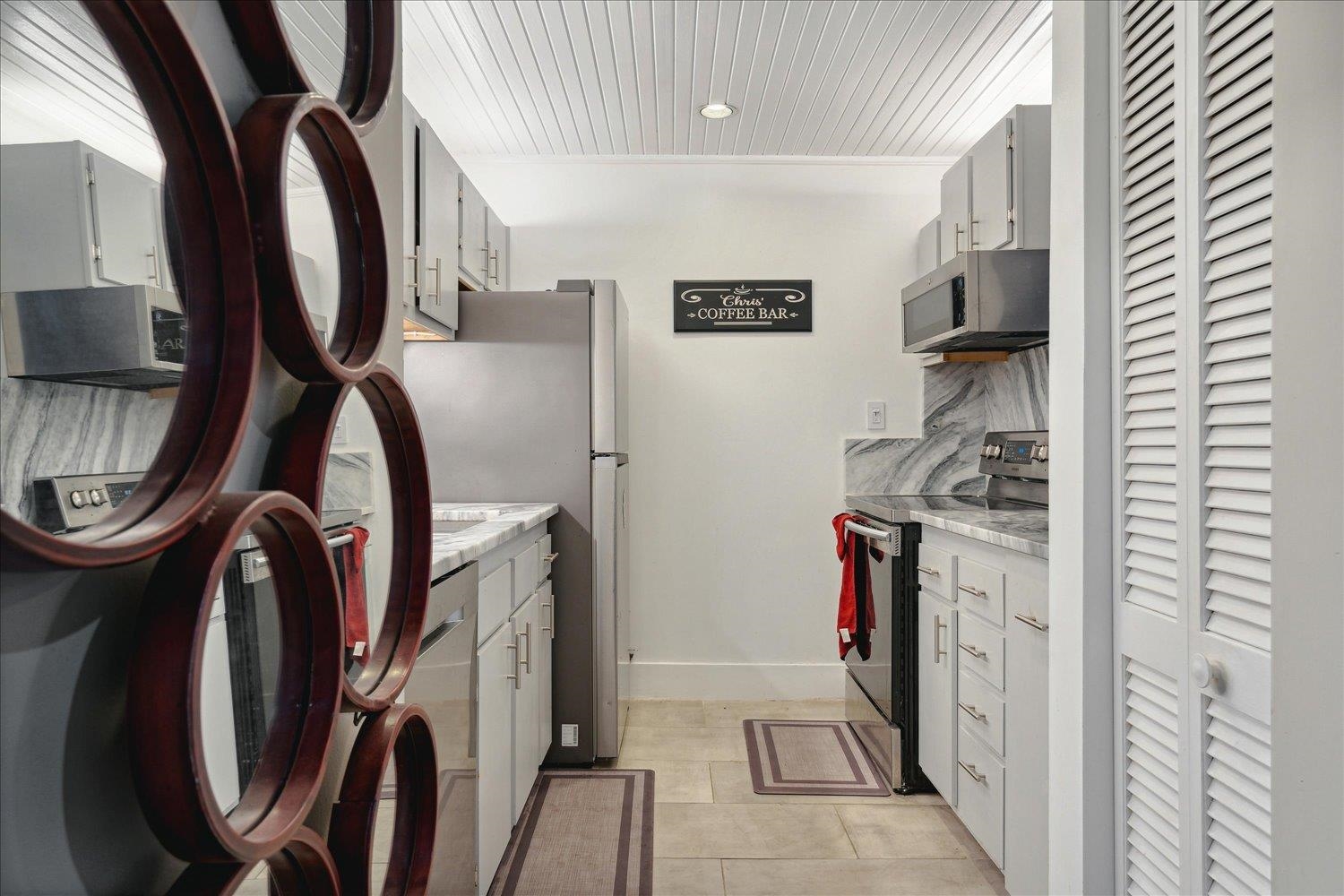 Kitchen with decorative backsplash, light tile patterned floors, and stainless steel appliances