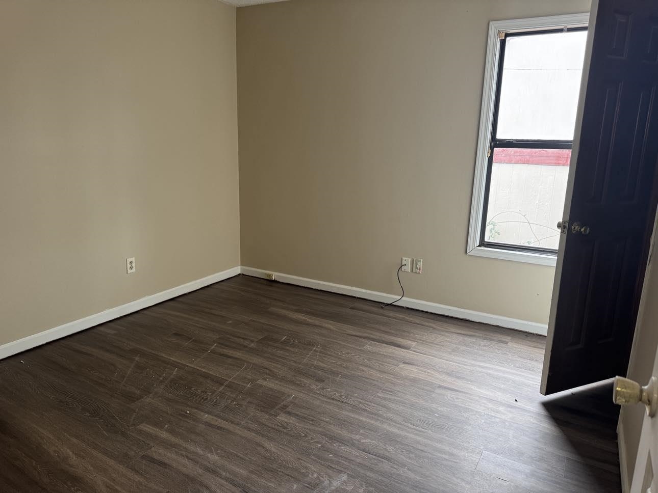 Unfurnished room featuring dark hardwood / wood-style flooring