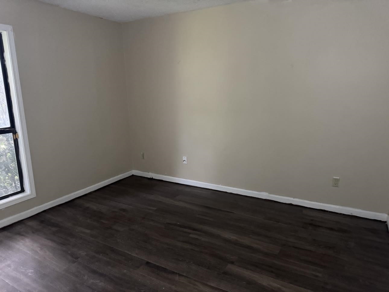 Empty room with dark hardwood / wood-style floors