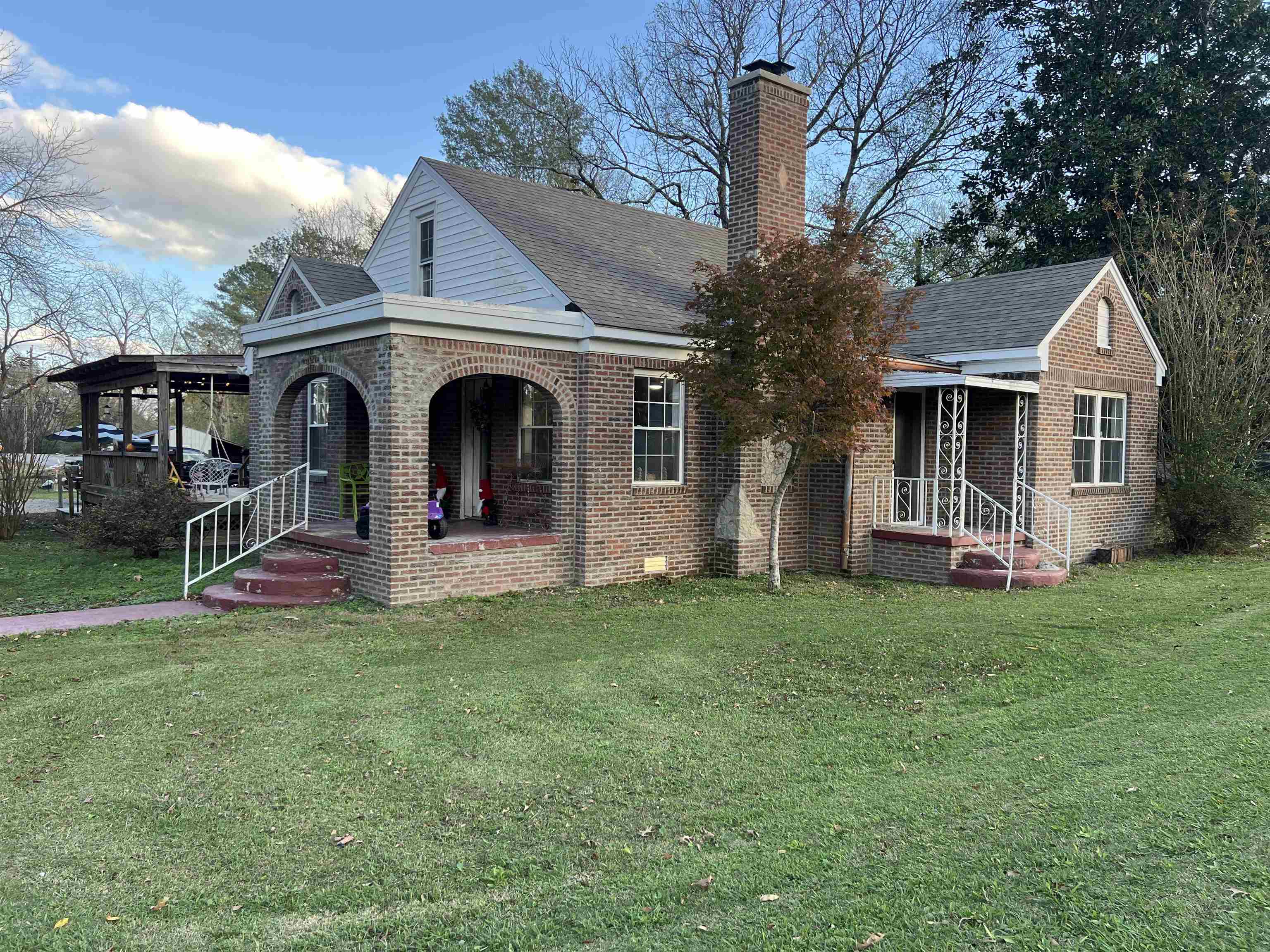 View of front of property featuring covered porch and a front yard