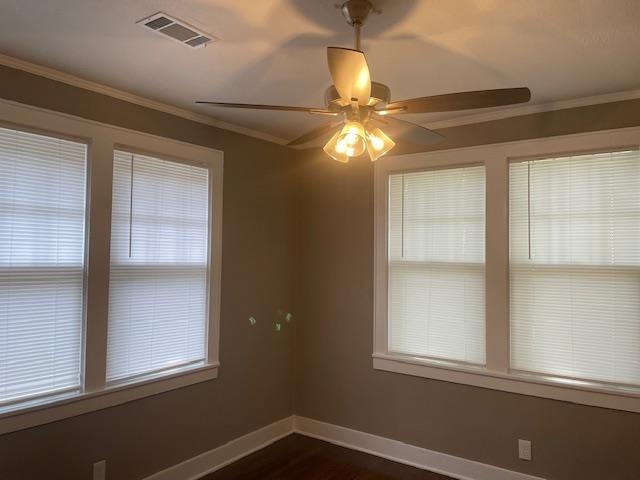 Spare room featuring ceiling fan, plenty of natural light, and ornamental molding