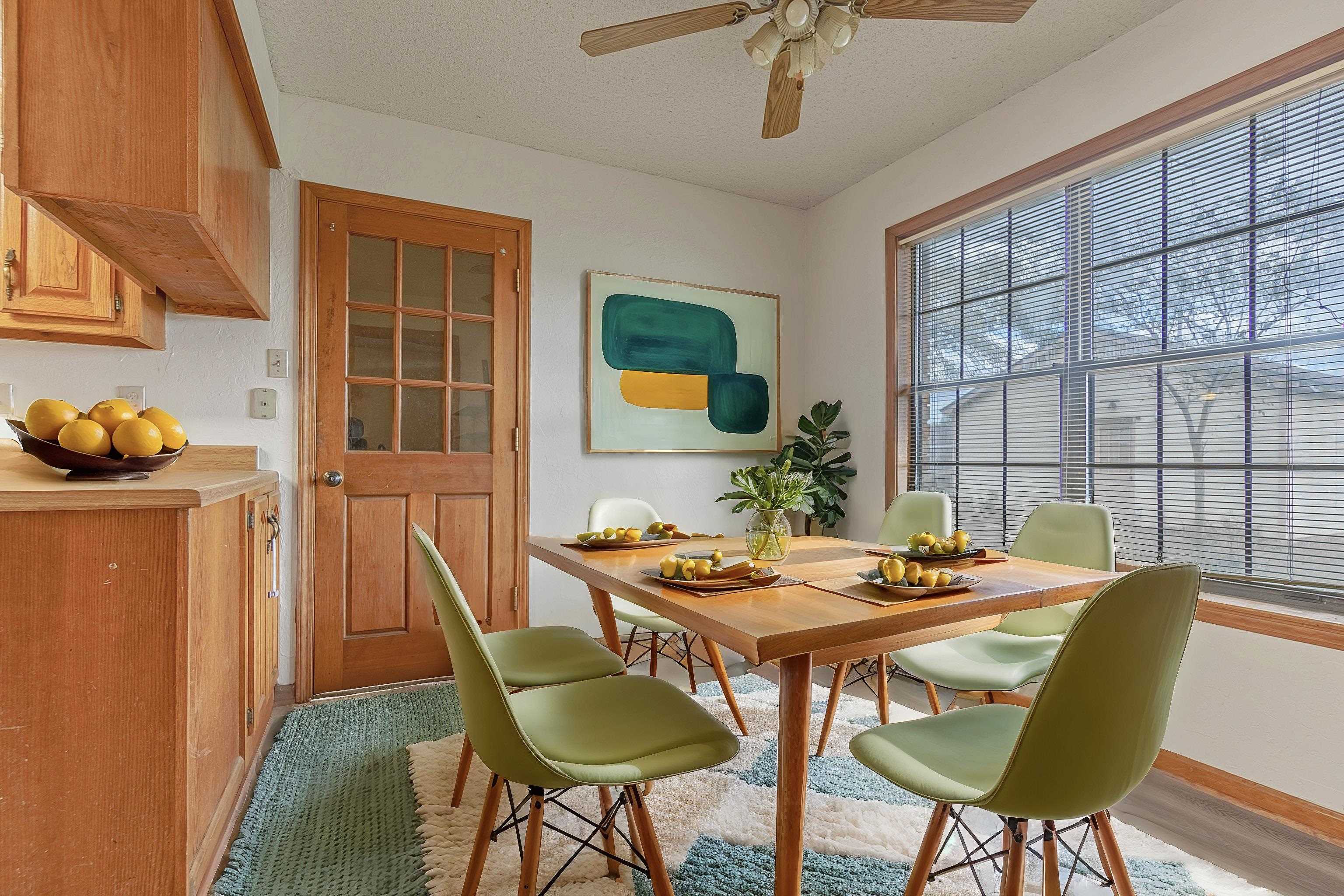 Dining room with ceiling fan, light wood-type flooring, and a textured ceiling