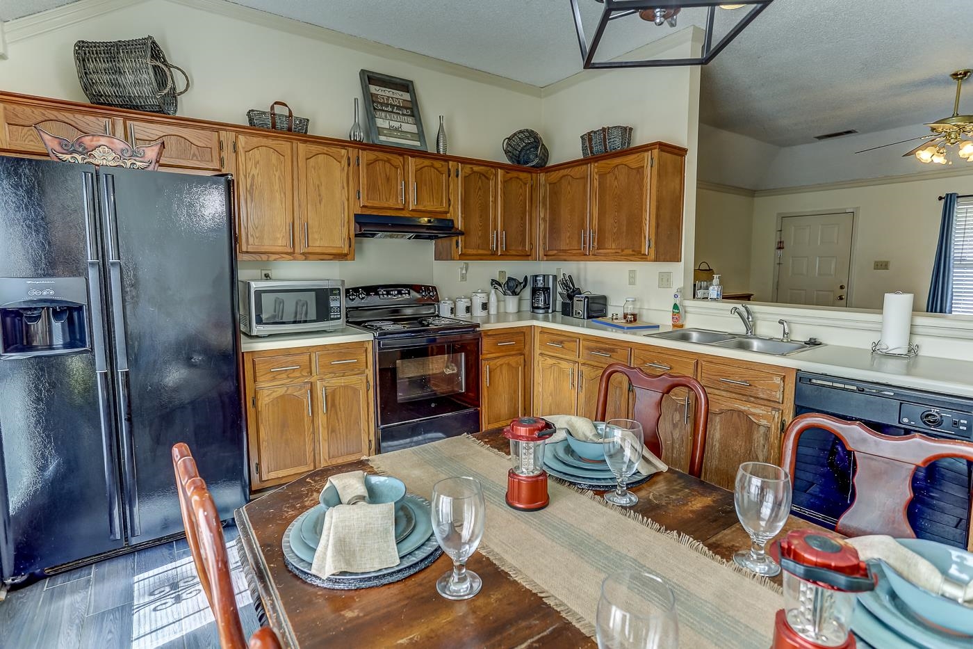 Kitchen with ceiling fan, sink, crown molding, a textured ceiling, and black appliances