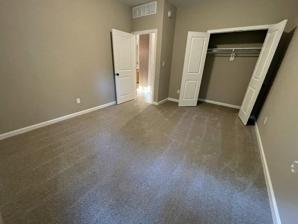 Unfurnished bedroom featuring carpet and a closet