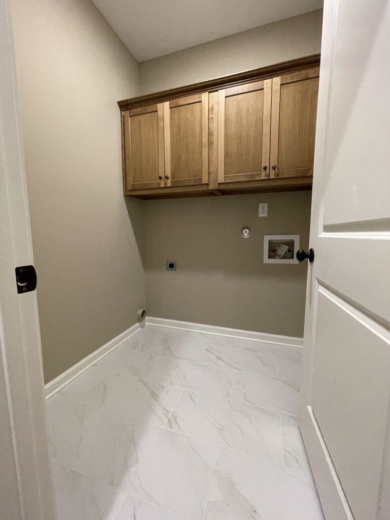 Clothes washing area with electric dryer hookup, hookup for a gas dryer, hookup for a washing machine, and cabinets