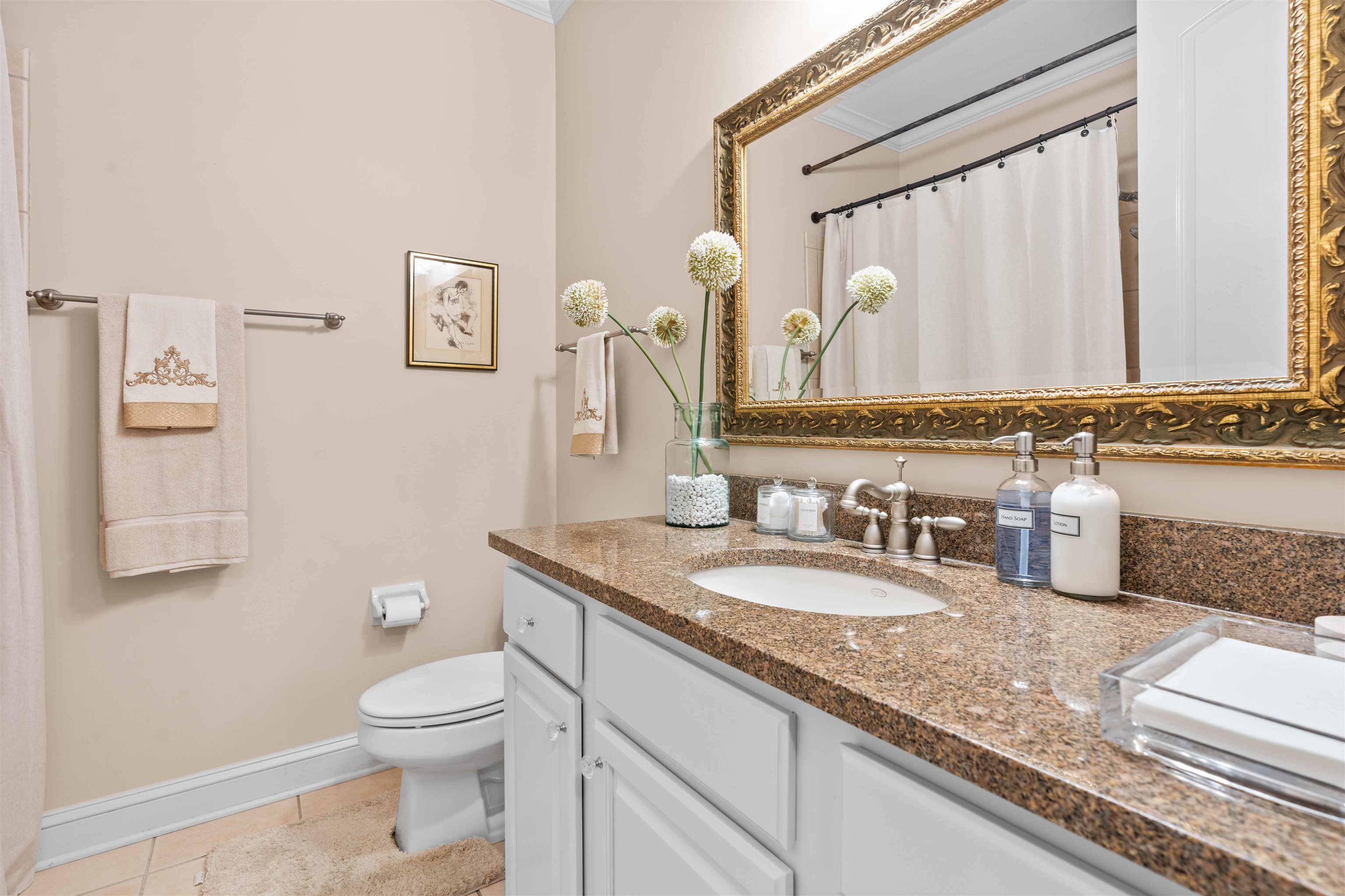 Bathroom featuring tile patterned flooring, a shower with curtain, vanity, and toilet