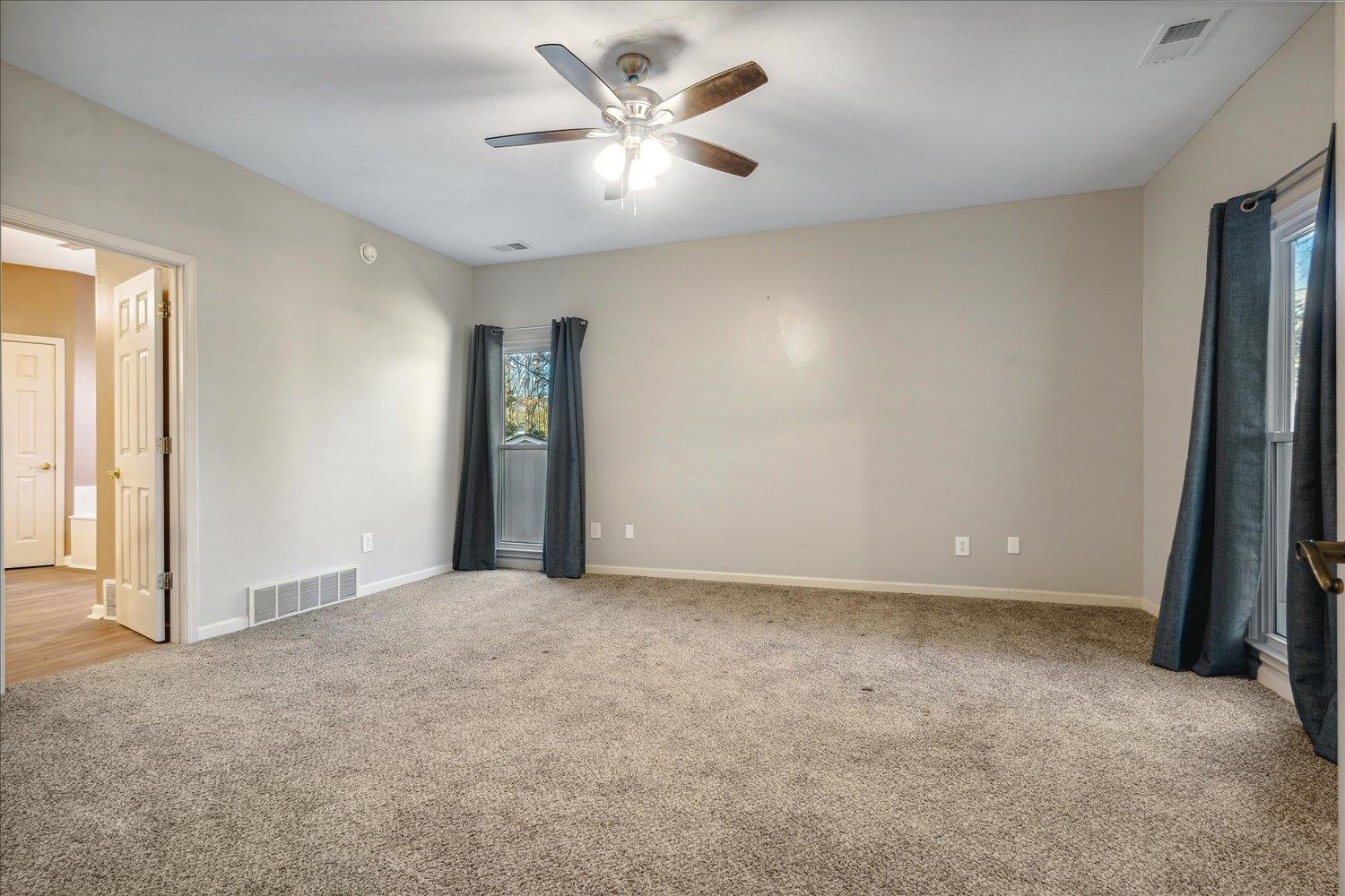 Spare room with ceiling fan and light colored carpet