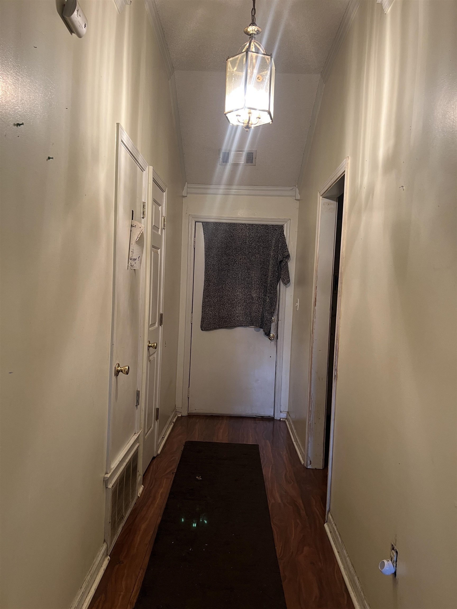 Hall featuring crown molding, dark hardwood / wood-style floors, and vaulted ceiling