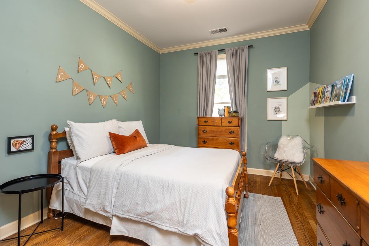 Bedroom featuring dark hardwood / wood-style flooring and crown molding