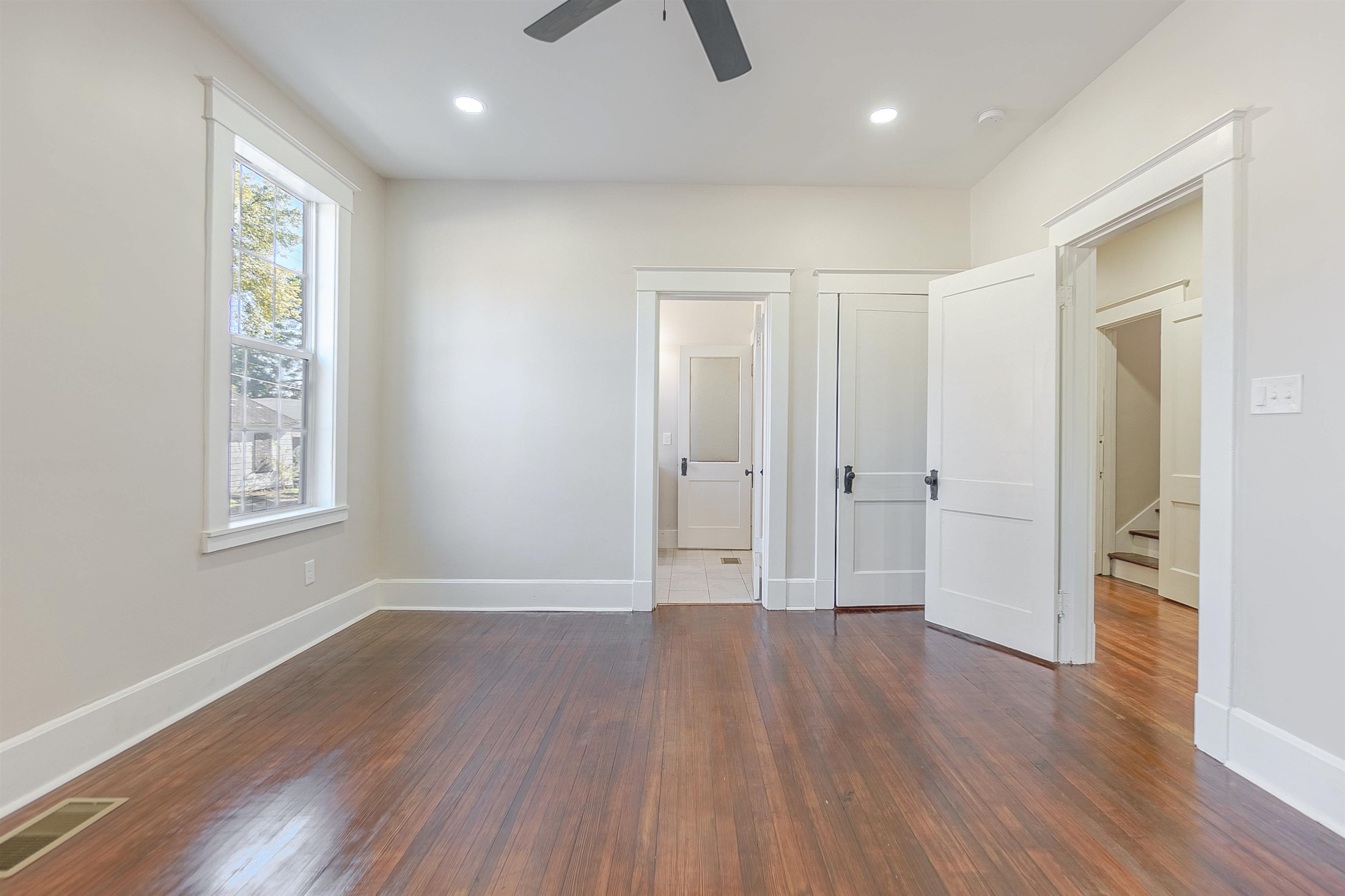 Unfurnished bedroom featuring ceiling fan and dark wood-type flooring