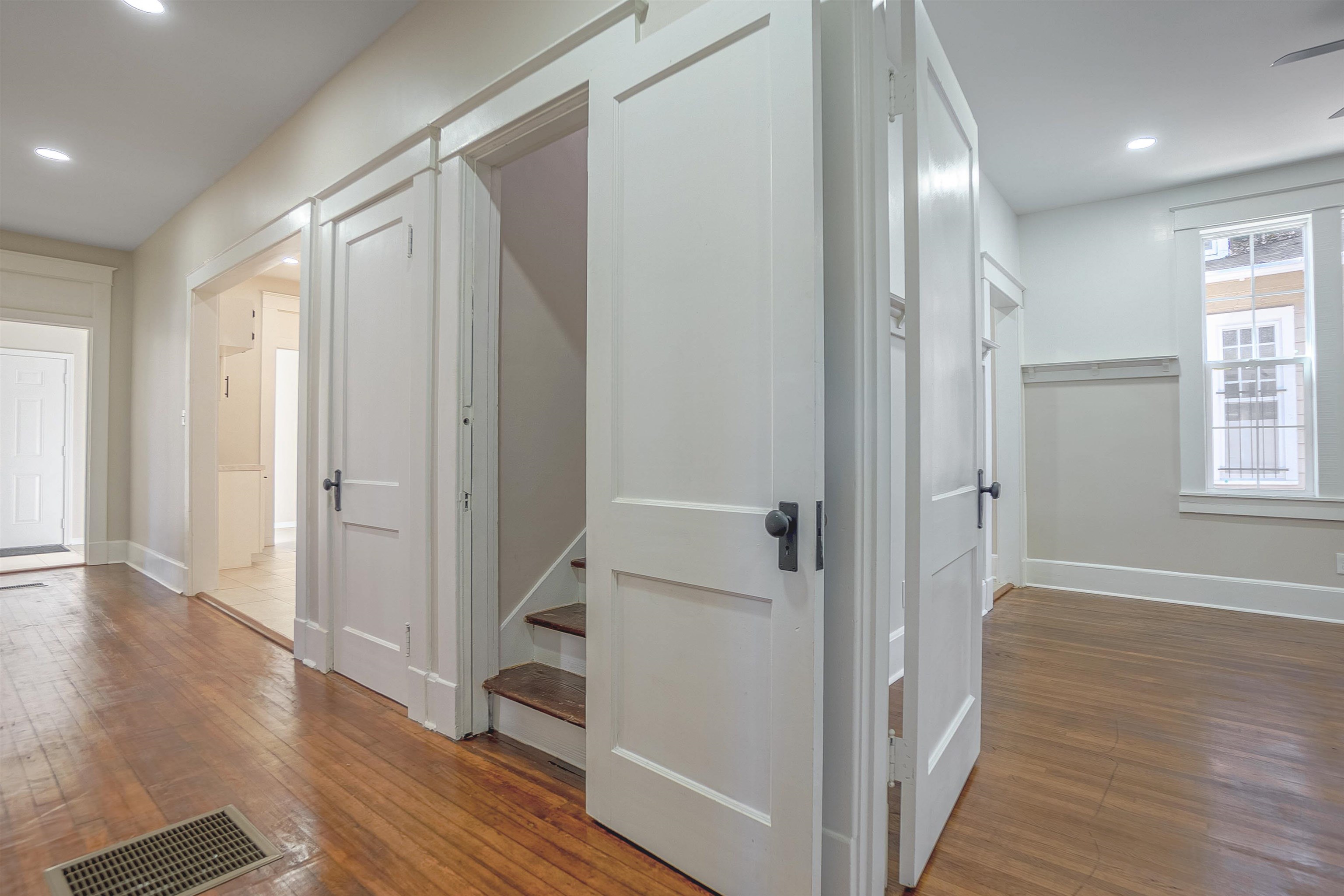 Hallway with hardwood / wood-style floors