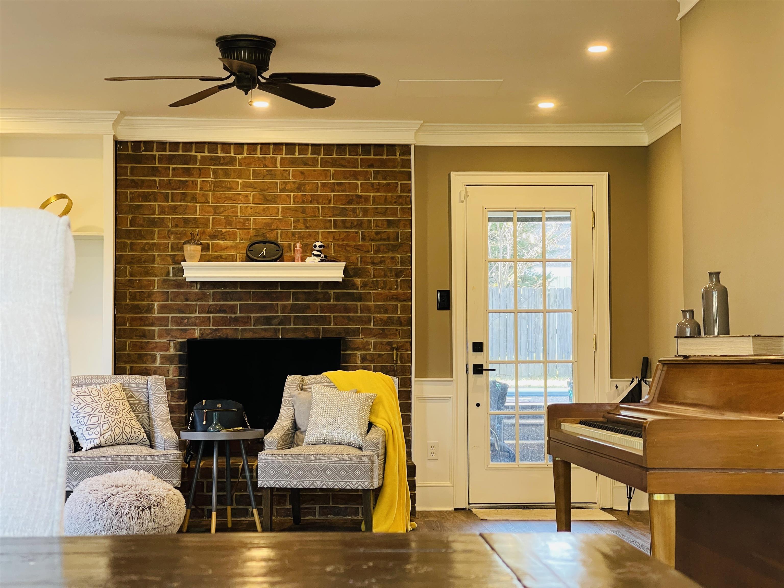 Doorway to outside featuring ceiling fan, wood-type flooring, and ornamental molding