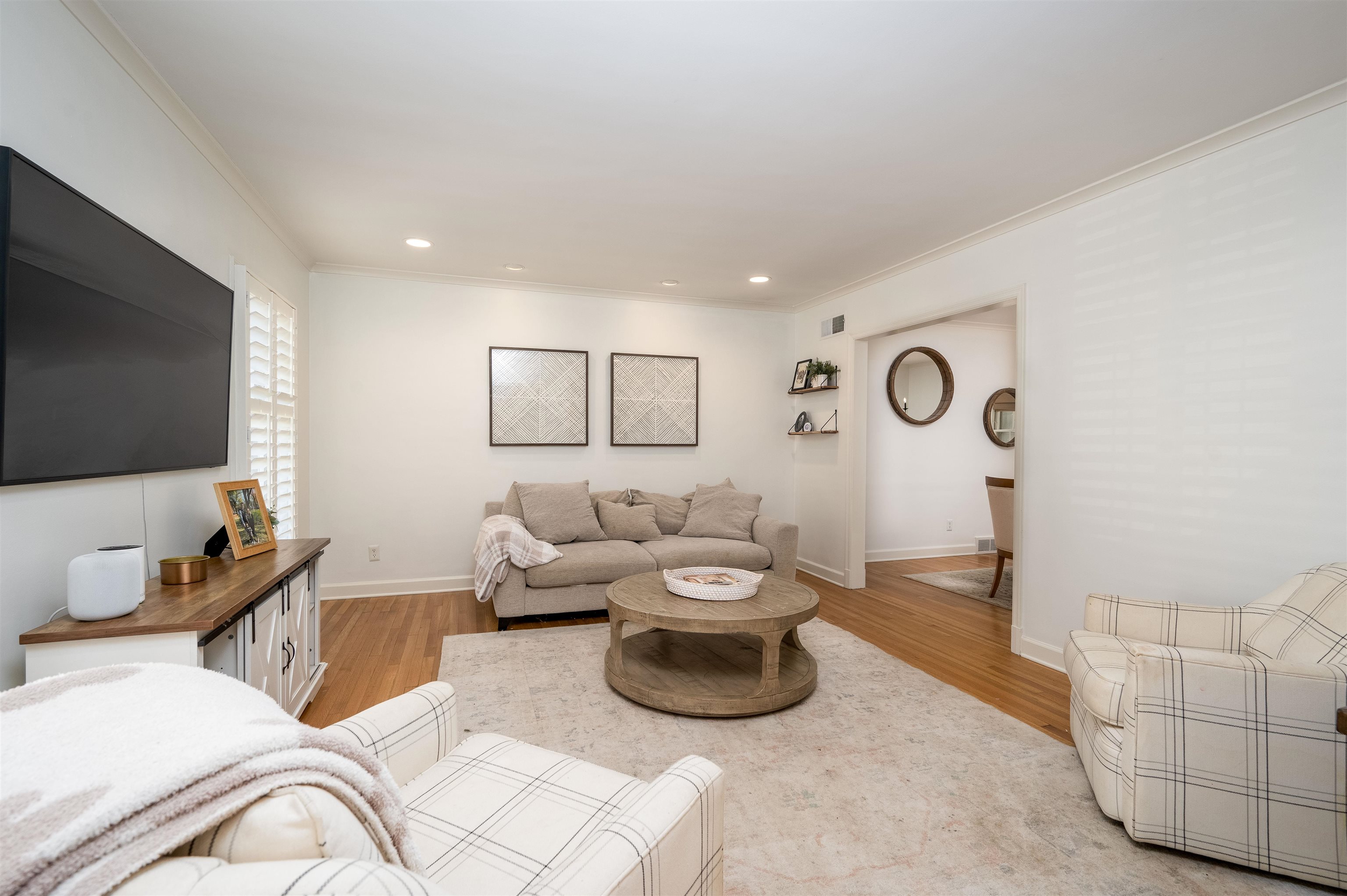 Living room with light hardwood / wood-style flooring and crown molding