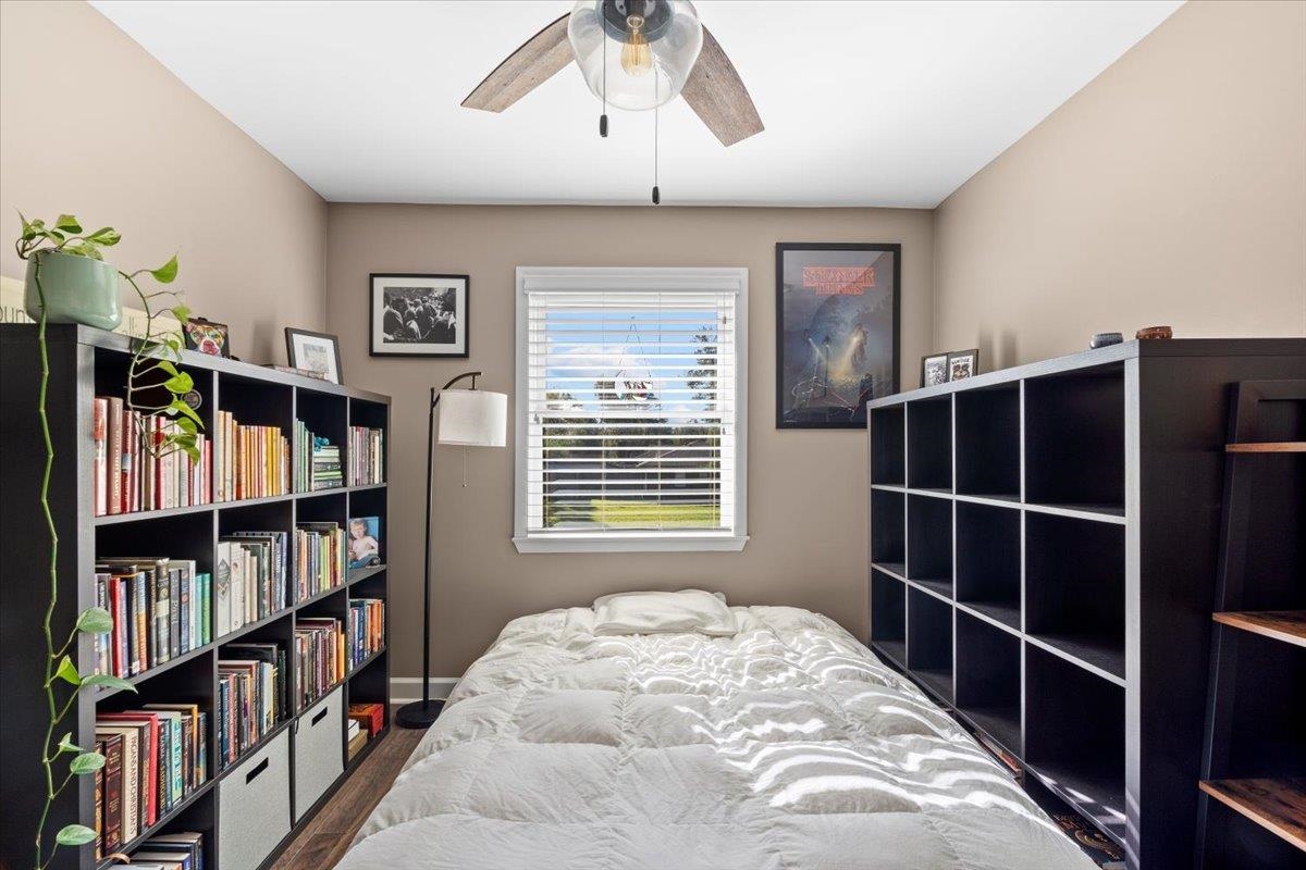 Bedroom with ceiling fan and dark wood-type flooring