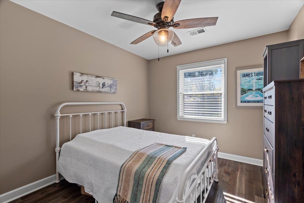 Bedroom featuring ceiling fan and dark wood-type flooring