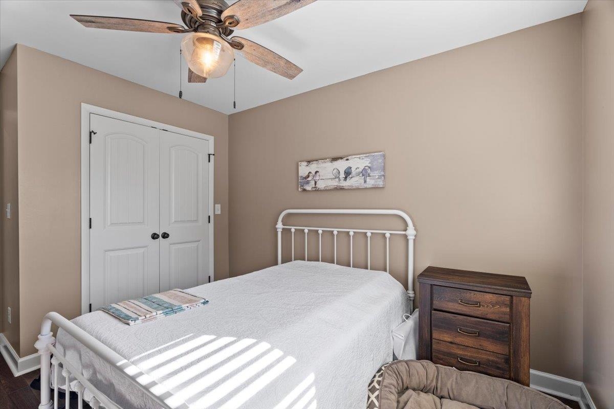 Bedroom with wood-type flooring, a closet, and ceiling fan