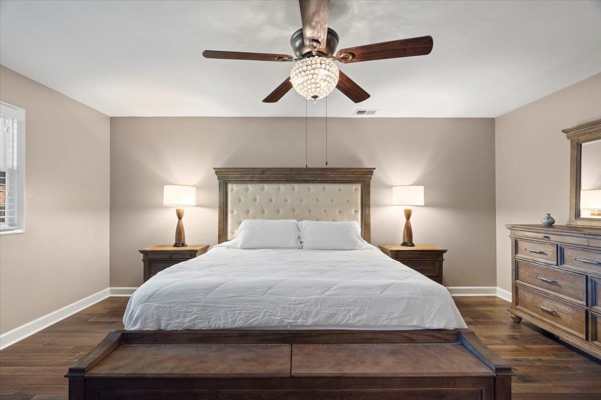 Bedroom with dark hardwood / wood-style flooring and ceiling fan