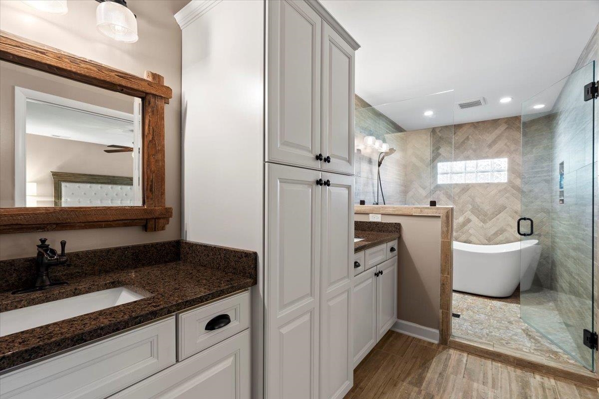 Bathroom with separate shower and tub, ceiling fan, hardwood / wood-style floors, and vanity