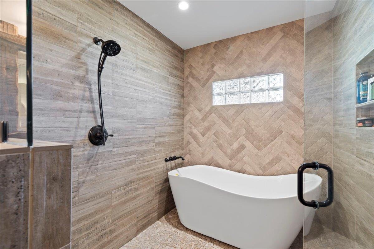 Bathroom featuring a tub and tile walls