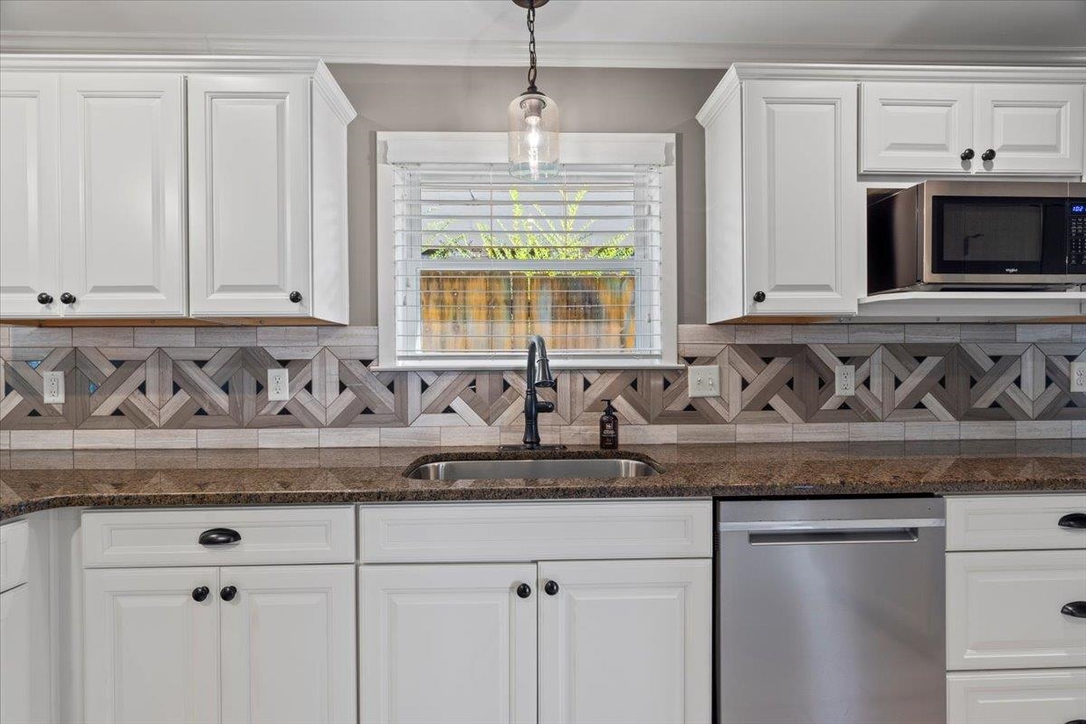 Kitchen with white cabinets, stainless steel appliances, and sink