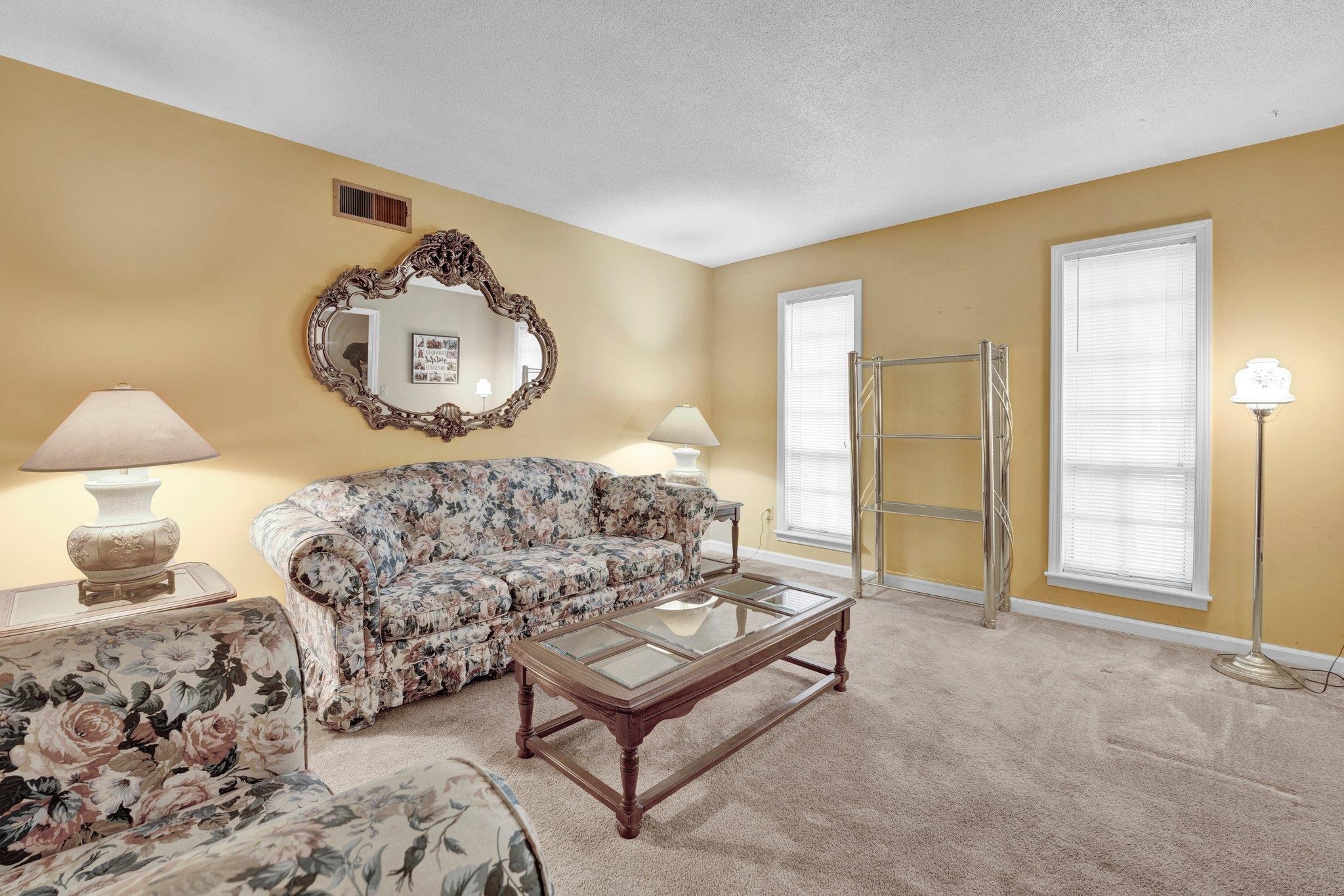 Living room featuring a textured ceiling and carpet floors