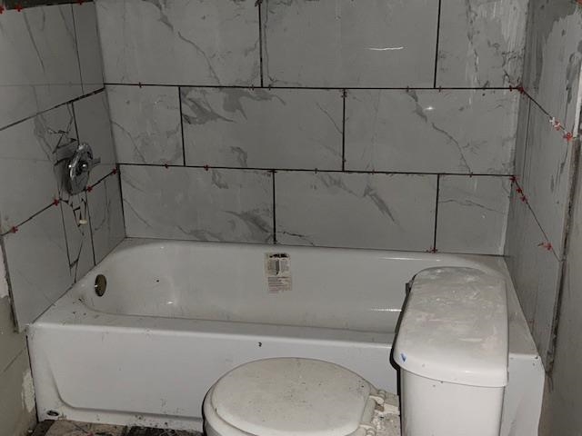 Bathroom featuring a tub to relax in and toilet