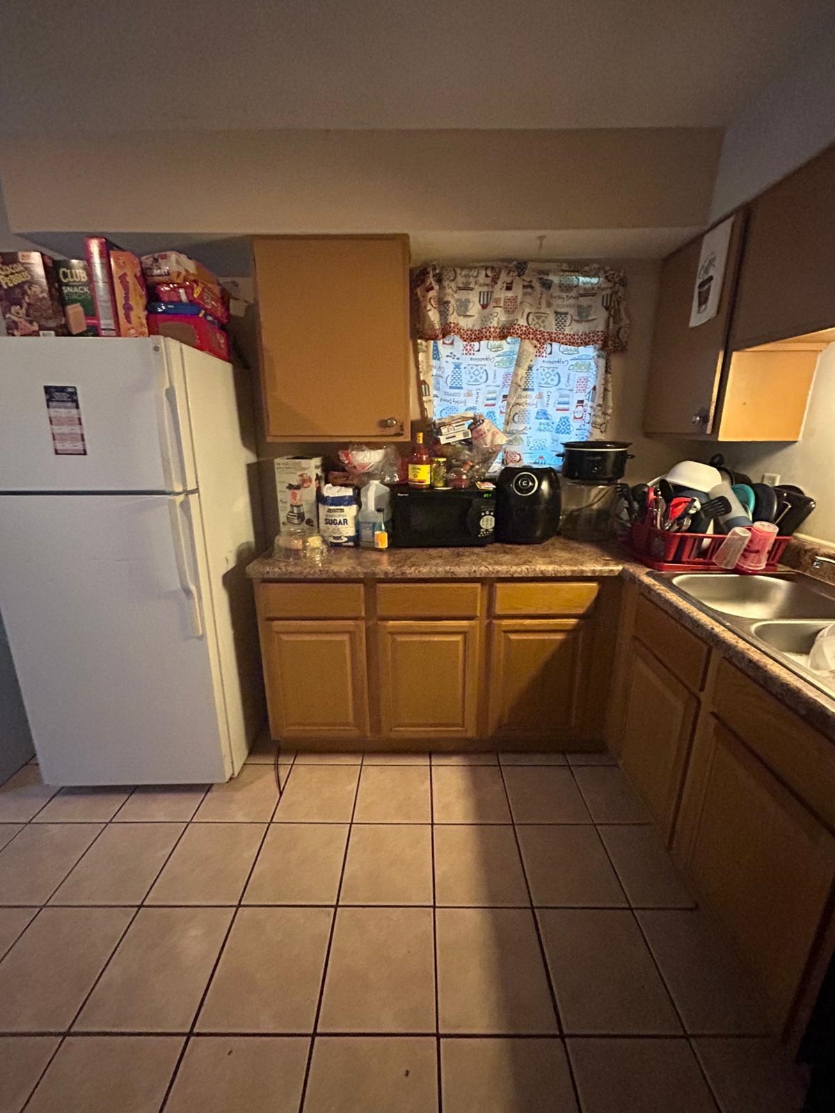 Kitchen with sink, light tile patterned floors, and white refrigerator