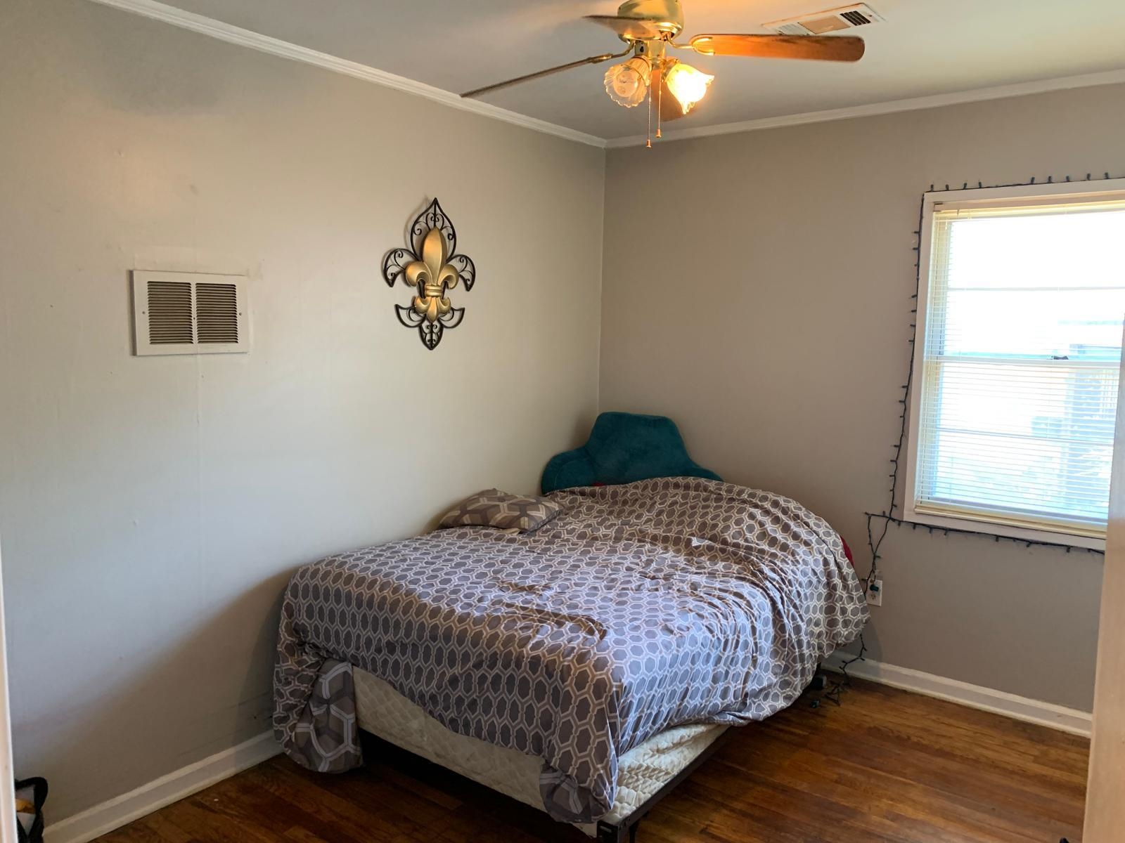 Bedroom featuring ceiling fan, dark hardwood / wood-style flooring, and crown molding