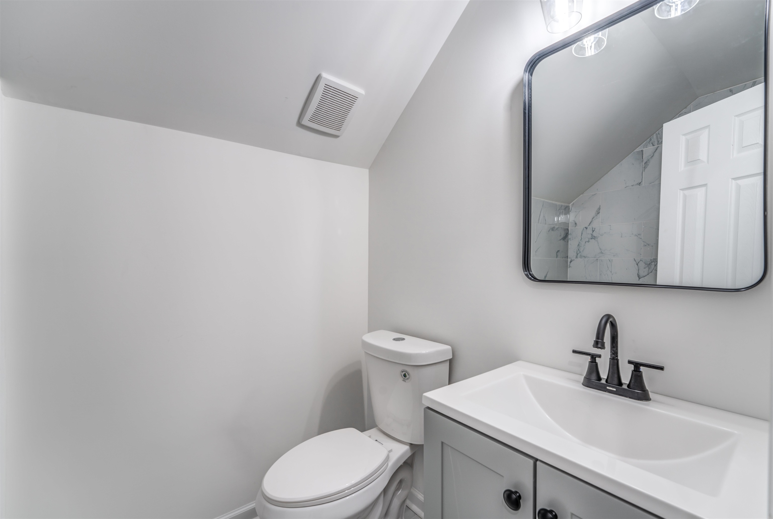 Bathroom with vanity, vaulted ceiling, and toilet