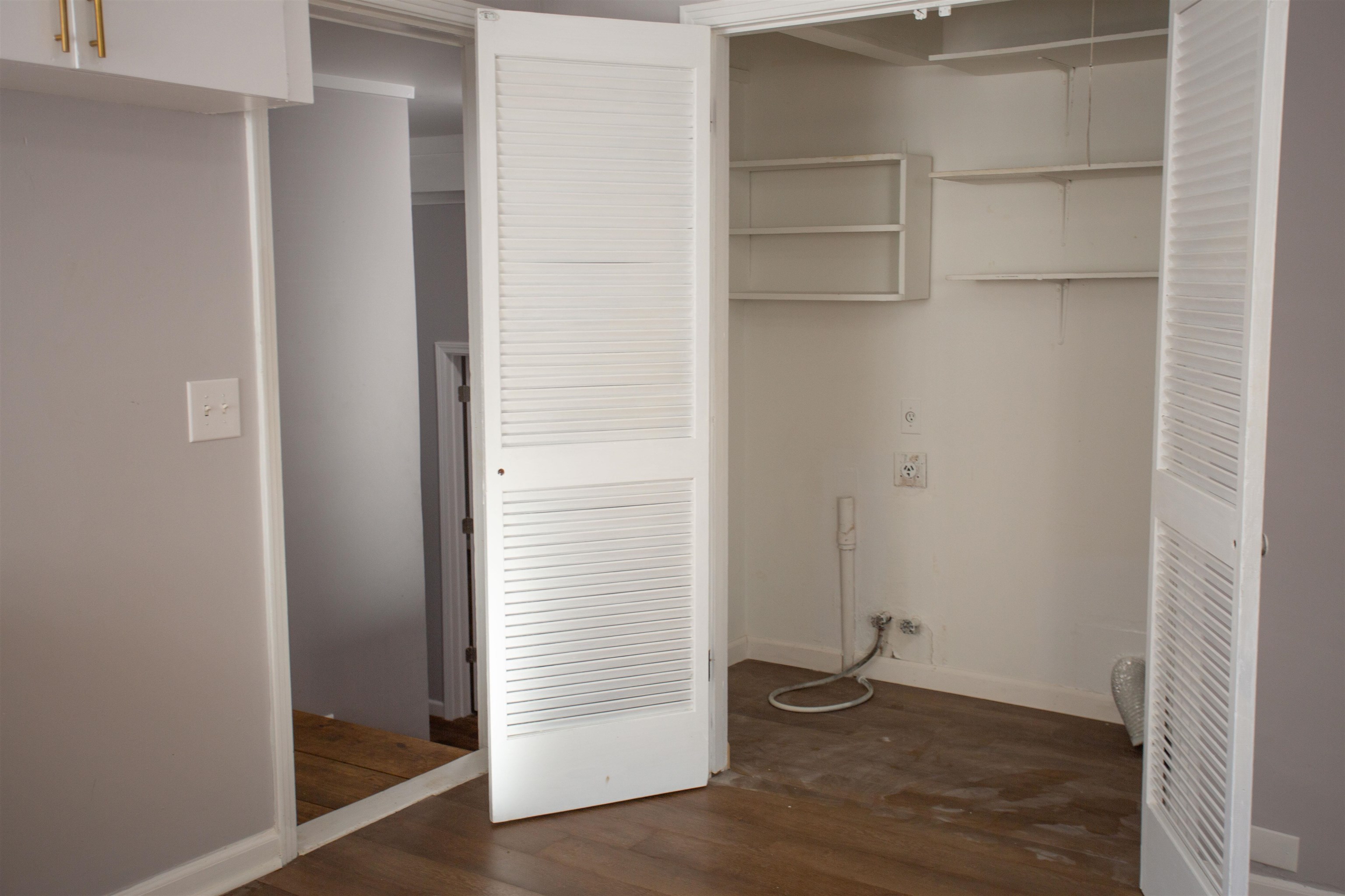 Laundry area featuring dark hardwood / wood-style floors