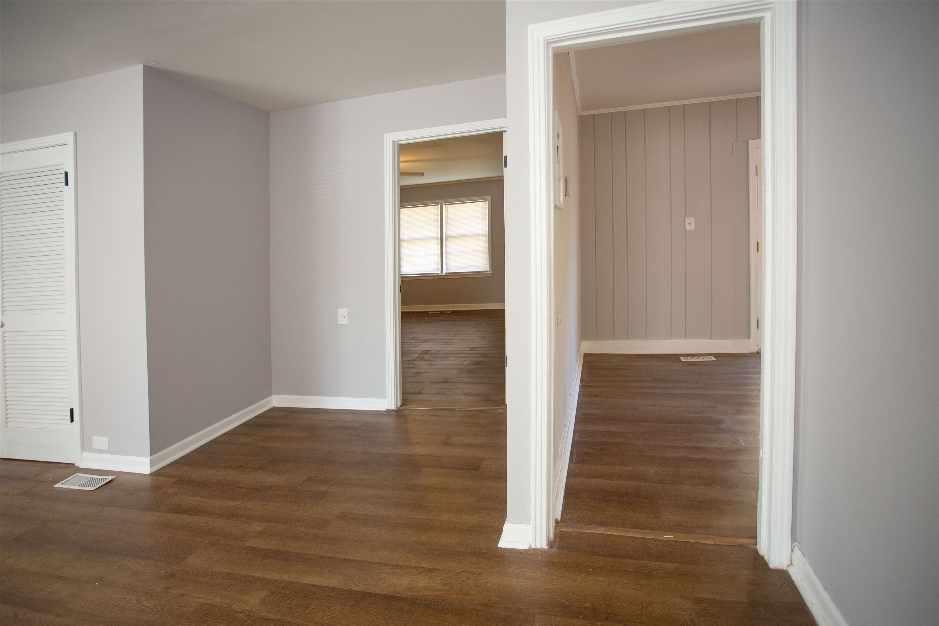 Hallway featuring wooden walls and dark hardwood / wood-style flooring