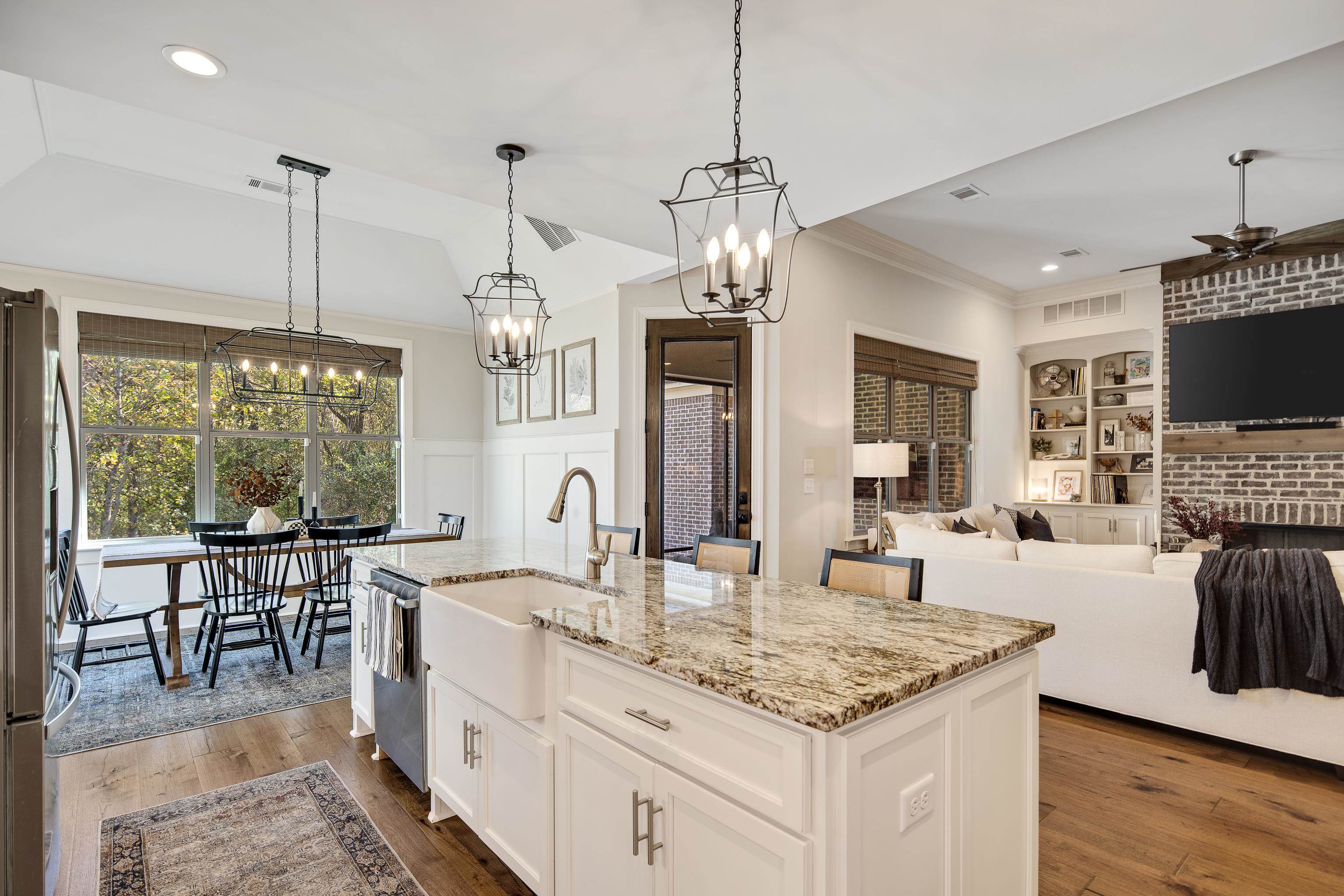 Kitchen featuring pendant lighting, built in shelves, an island with sink, and appliances with stainless steel finishes