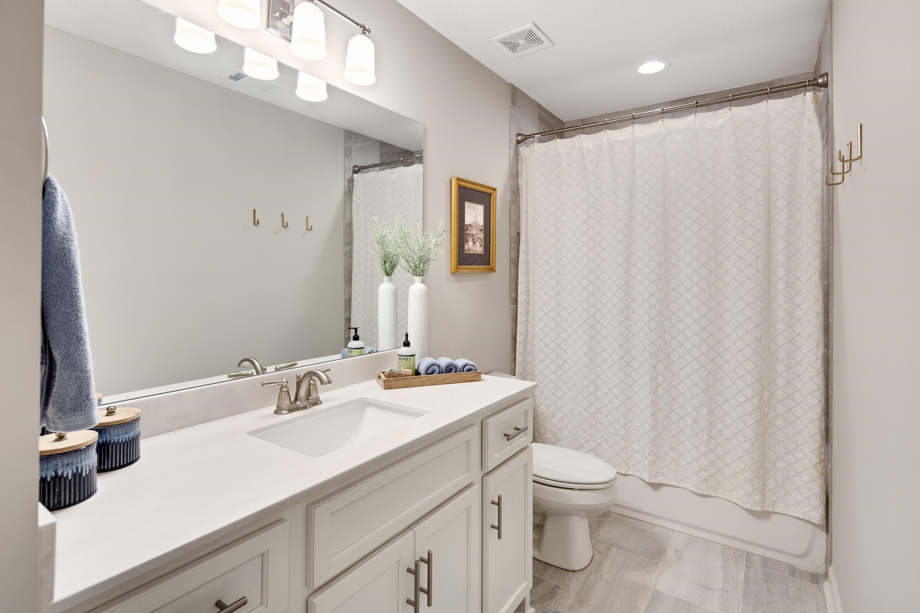 Full bathroom featuring vanity, shower / bath combination with curtain, and toilet