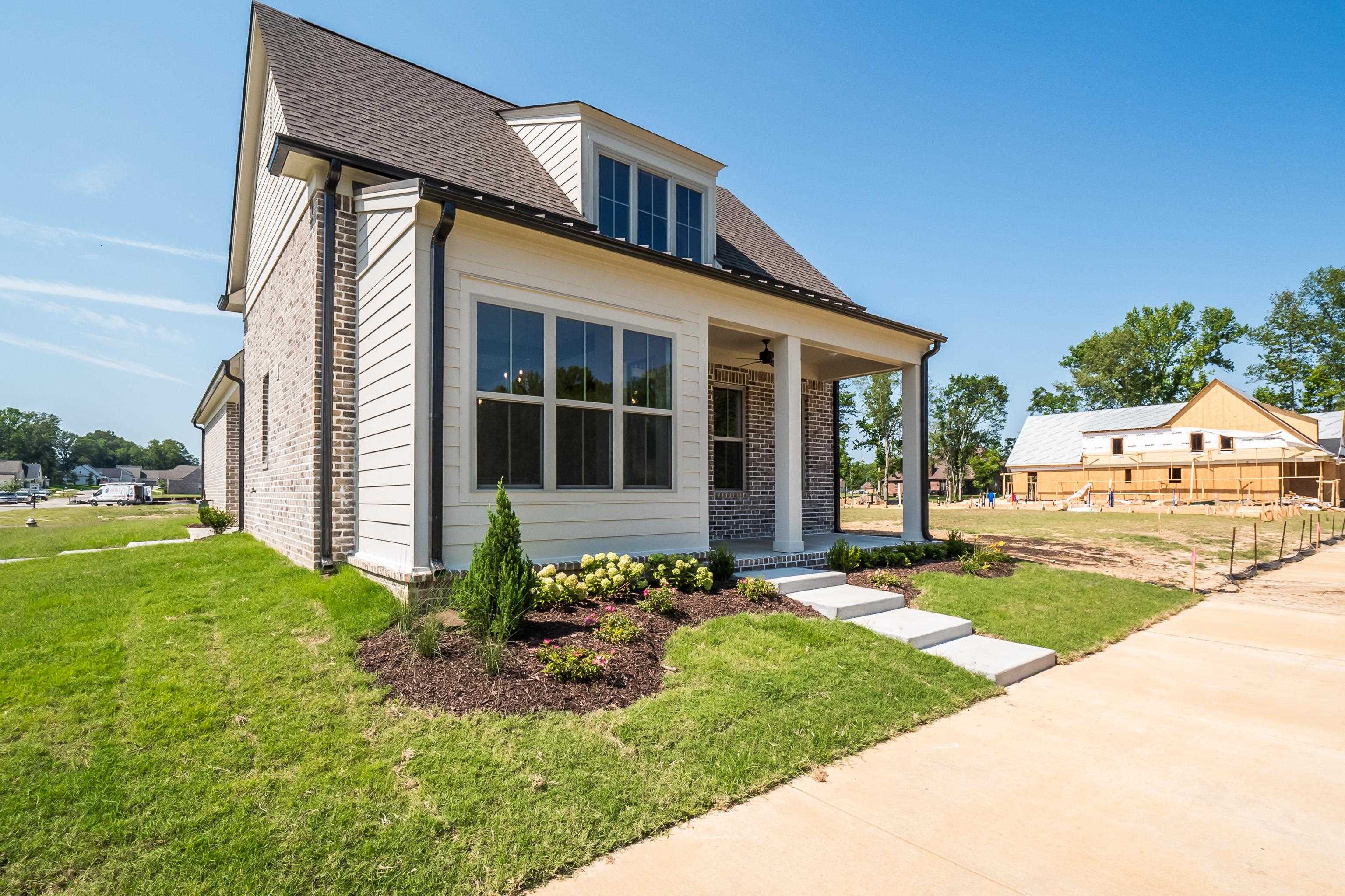 View of front of property with covered porch and a front yard