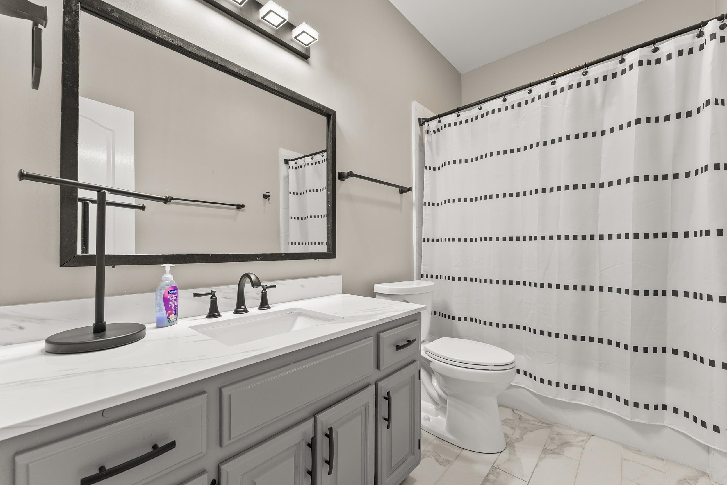 Bathroom with vanity, toilet, and walk in shower