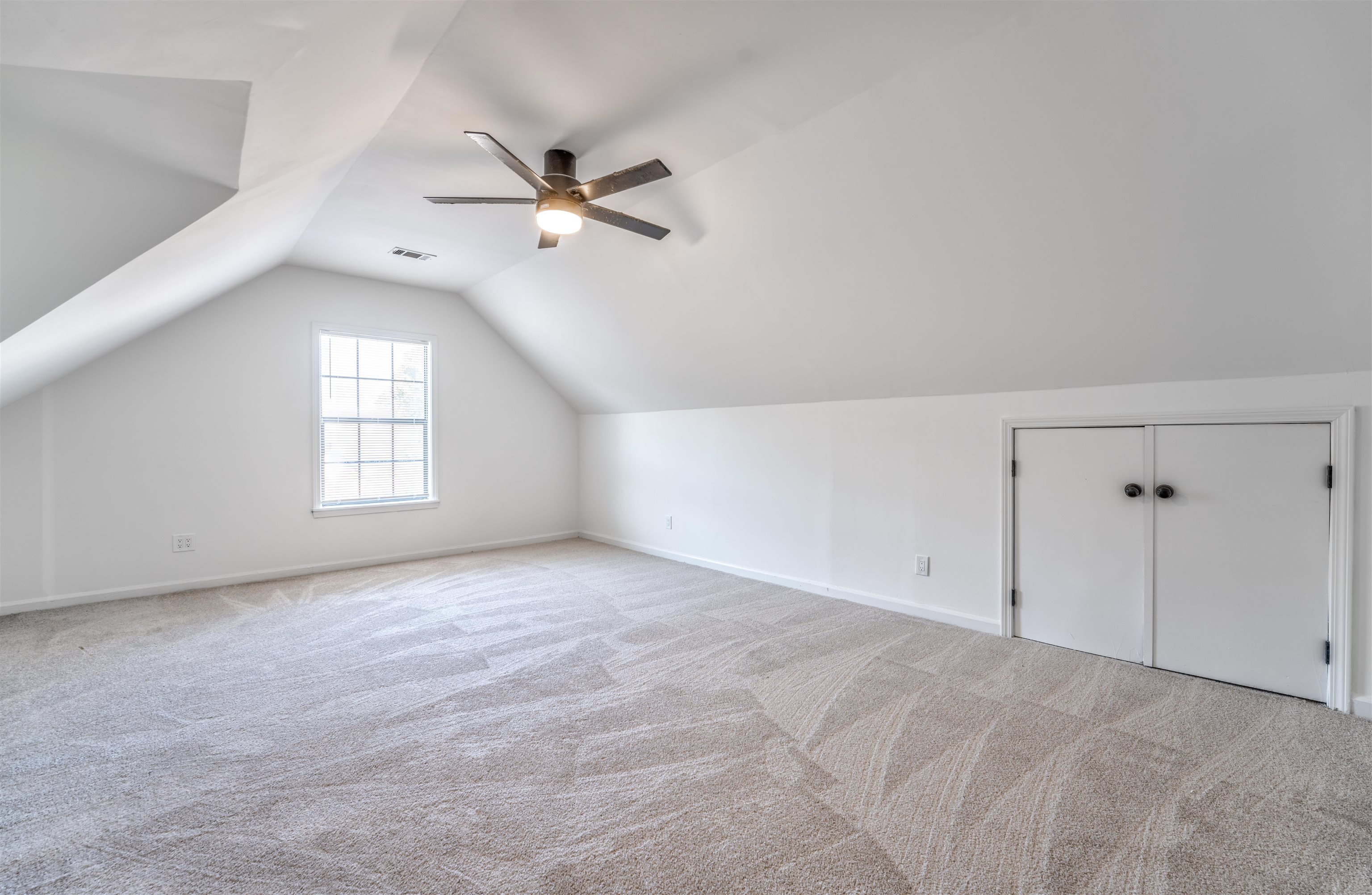 Bonus room featuring light carpet, lofted ceiling, and ceiling fan