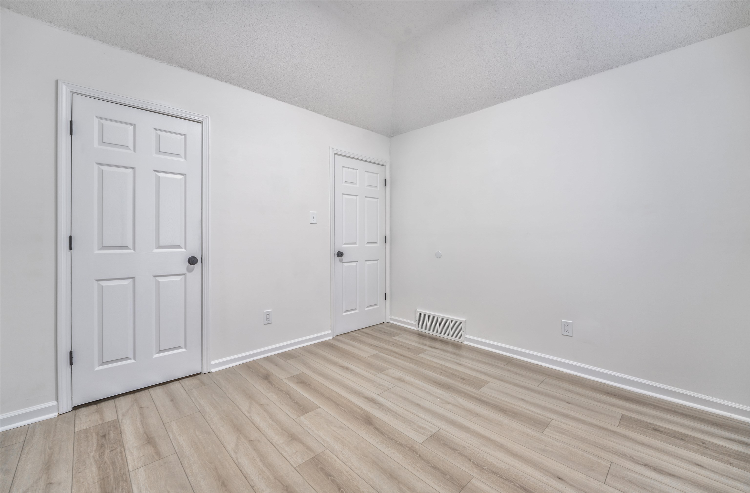 Empty room featuring a textured ceiling and light hardwood / wood-style flooring