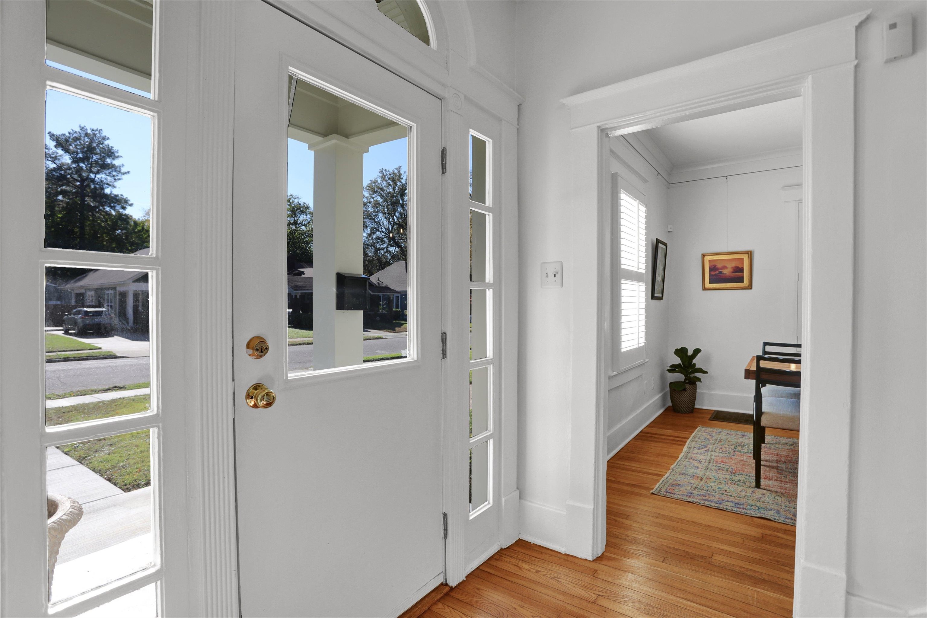 Entryway featuring light hardwood / wood-style floors, a wealth of natural light, and ornamental molding