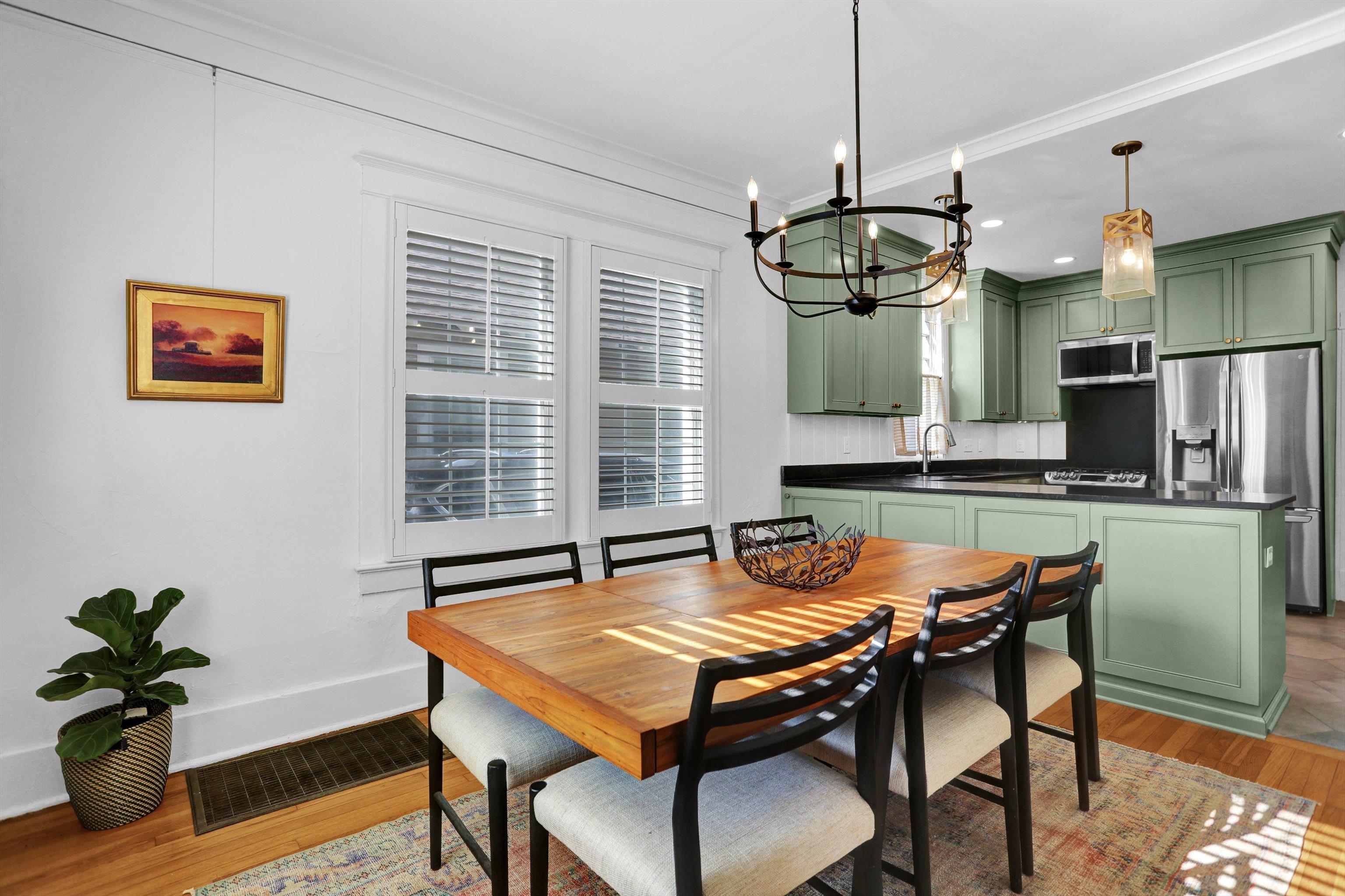 Dining area with a chandelier, sink, light hardwood / wood-style floors, and ornamental molding