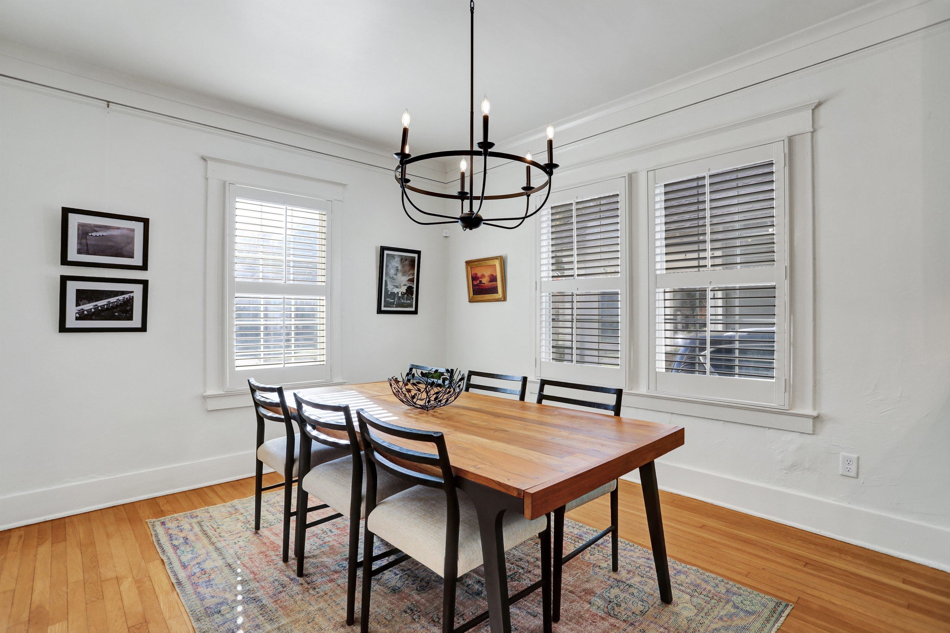 Dining room with light wood-type flooring, crown molding, and a notable chandelier