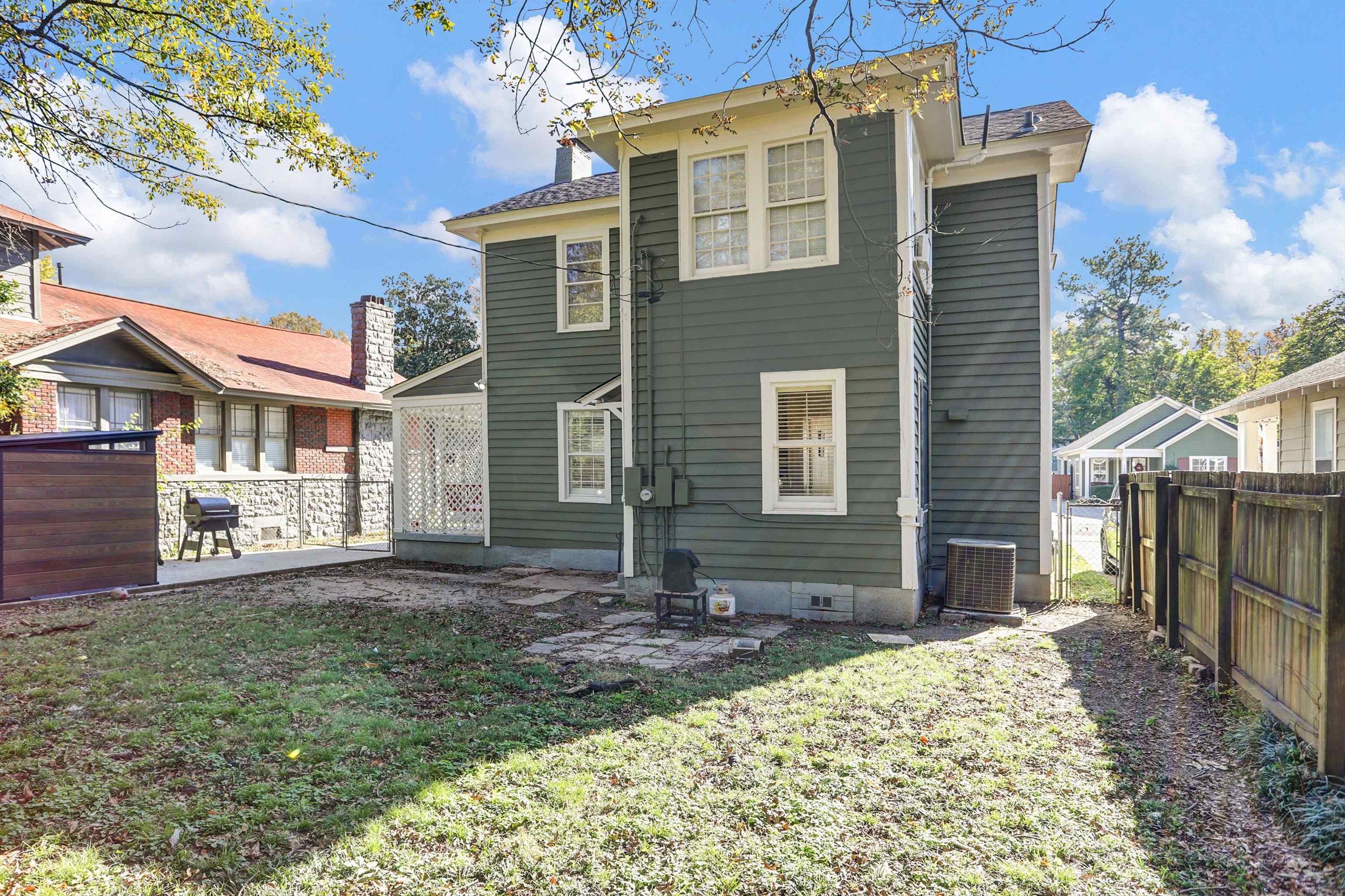 Back of property with a yard and central AC unit