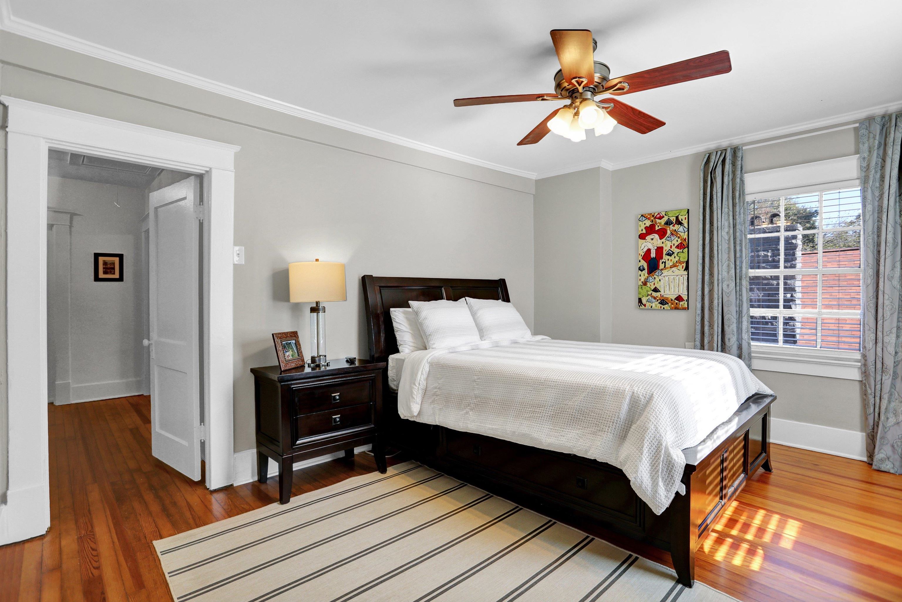 Bedroom with ceiling fan, crown molding, and wood-type flooring