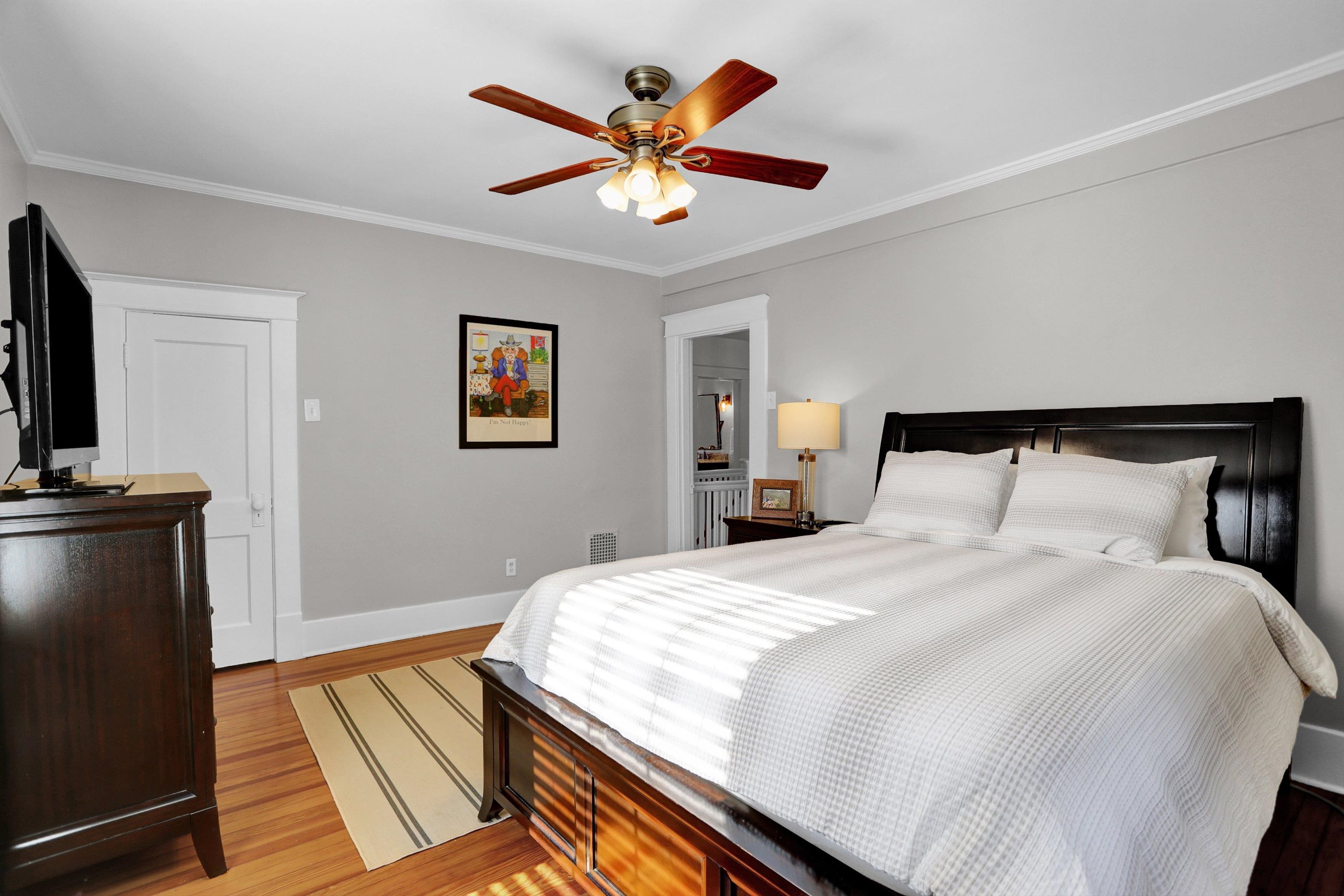 Bedroom with light hardwood / wood-style floors, ceiling fan, and crown molding