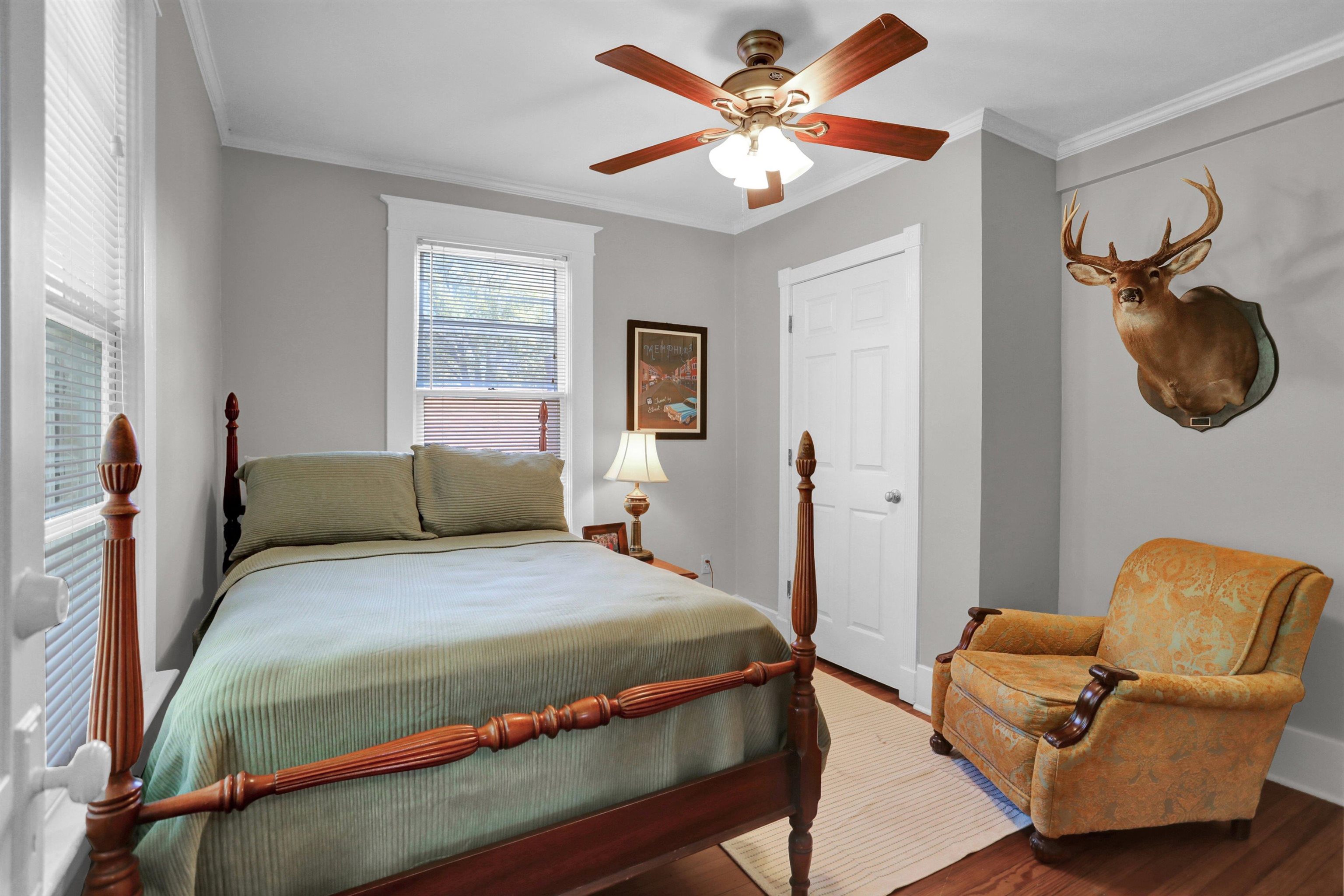 Bedroom featuring ceiling fan, hardwood / wood-style floors, and ornamental molding